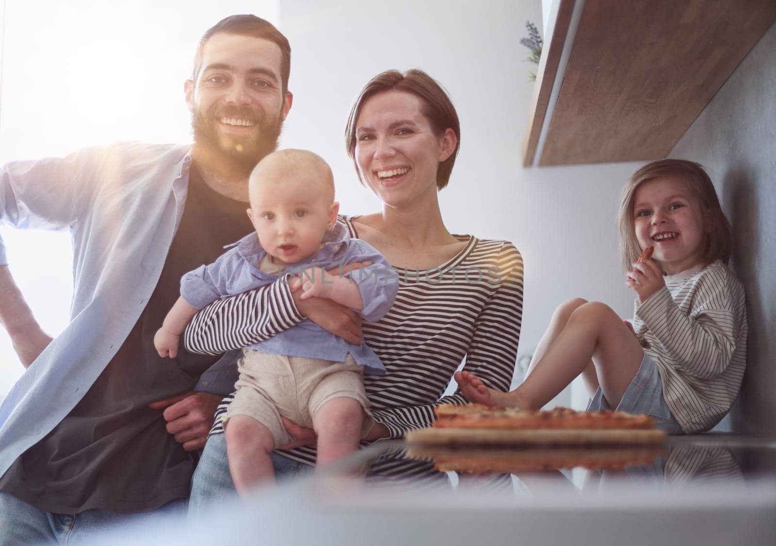 Young family with daughter and son in the kitchen