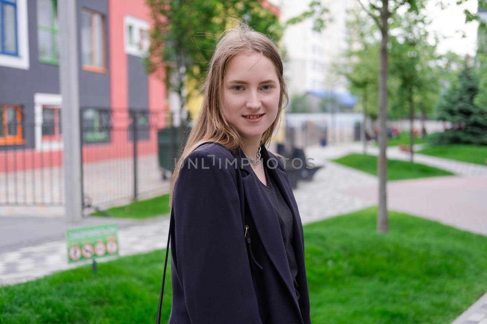 pretty brunette woman on background of bright modern buildings. feminine. millennial people. lady on walk.