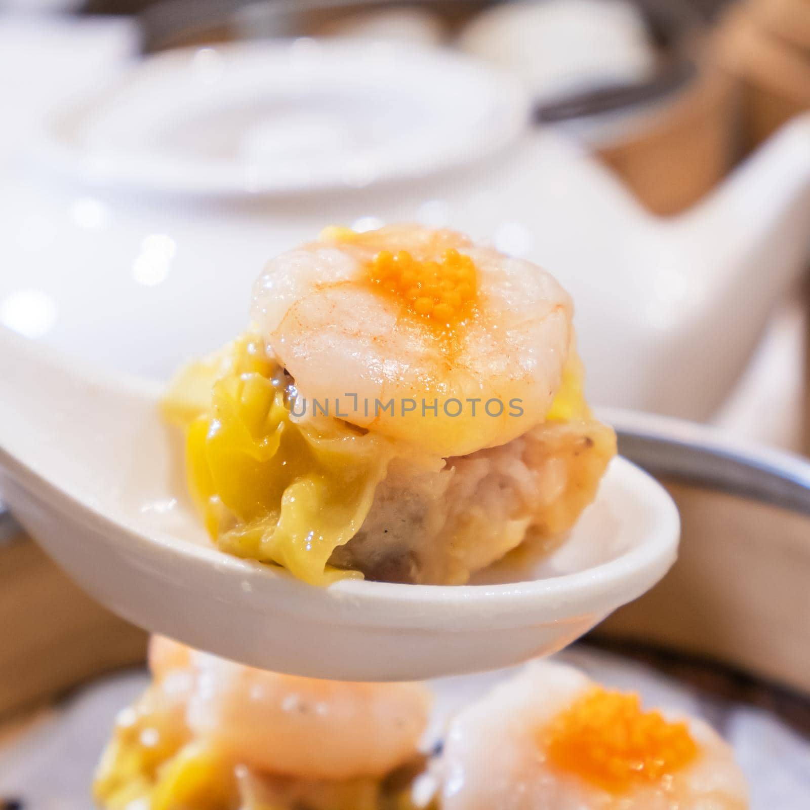 Siu Mai, one of Dim Sum yum cha, pork and shrimp steamed dumplings on restaurant house white background table for breakfast, lifestyle, close up.