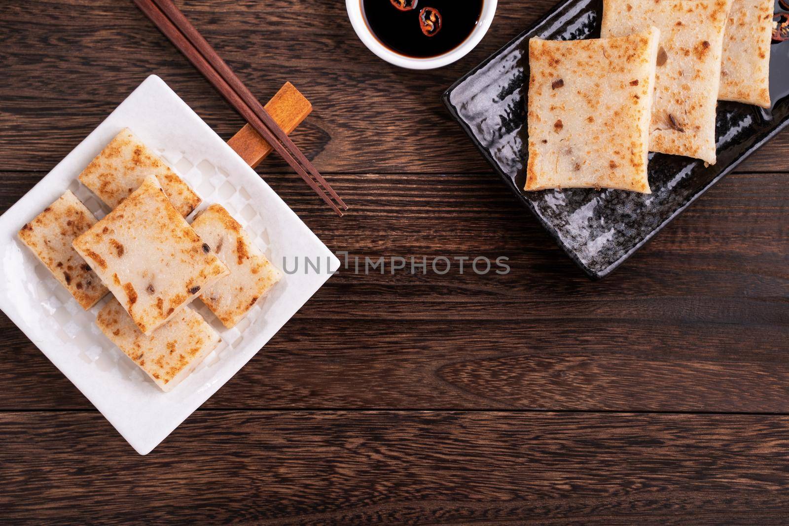 Delicious turnip cake, Chinese traditional radish cake in restaurant with soy sauce for new year's dishes, close up, copy space, top view, flat lay.