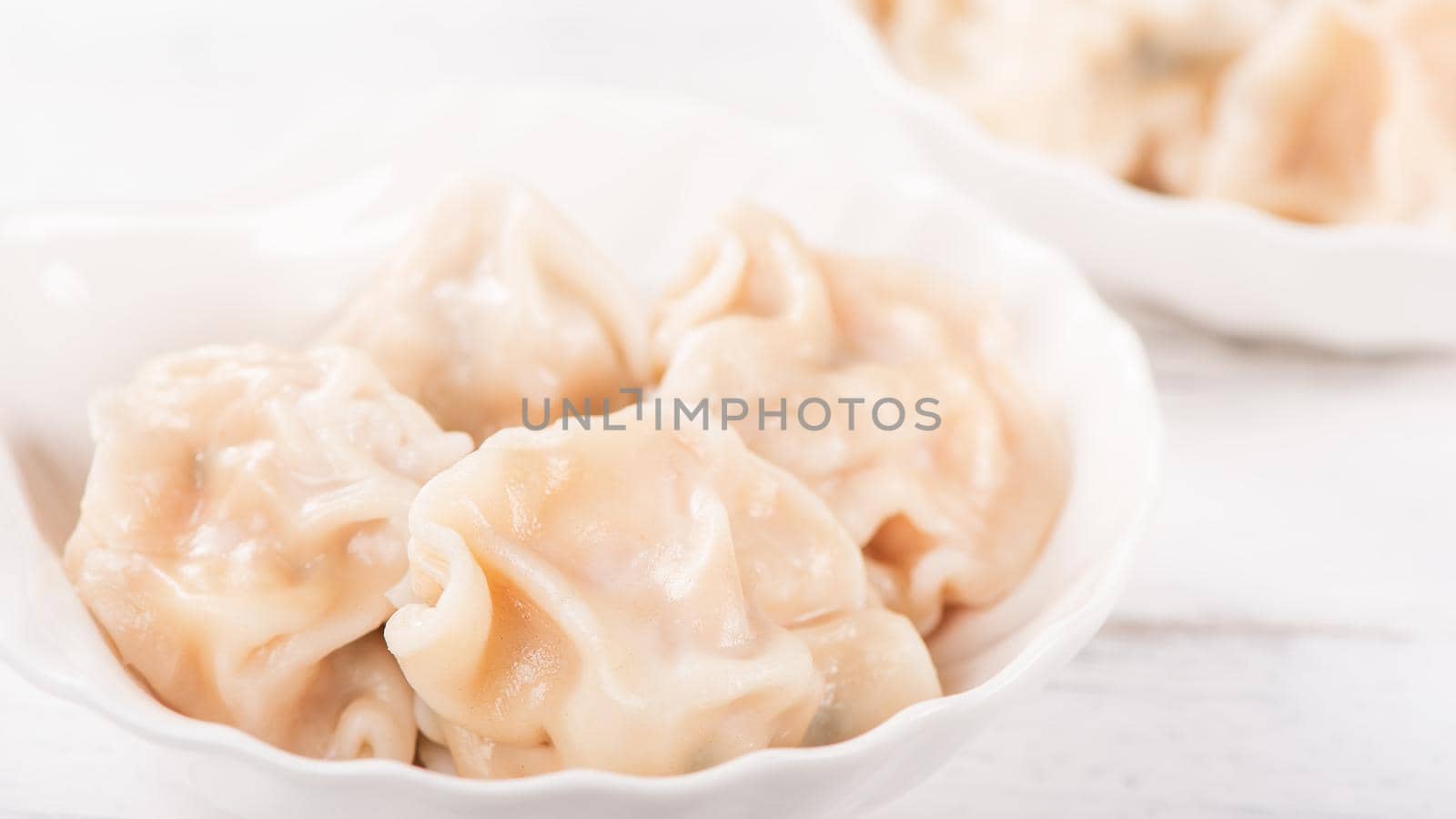 Fresh, delicious boiled pork, shrimp gyoza dumplings on white background with soy sauce and chopsticks, close up, lifestyle. Homemade design concept.