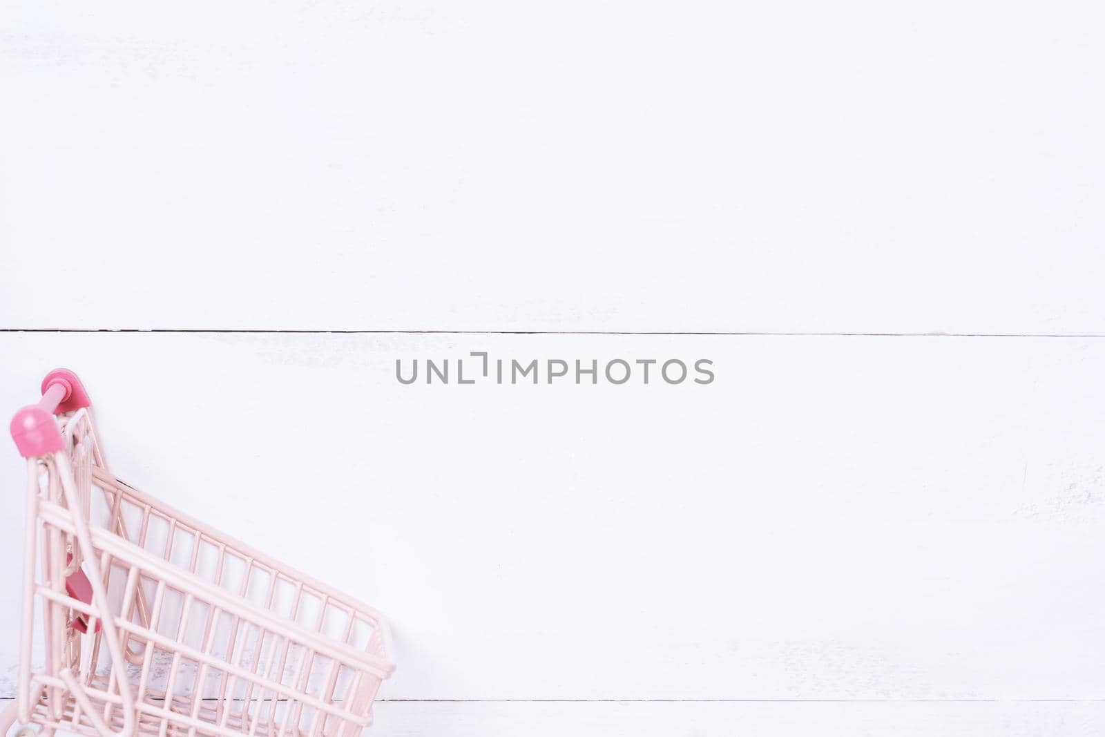 Abstract design element,annual sale,shopping season concept,mini cart with colorful paper bag on white wooden table background,top view,flat lay