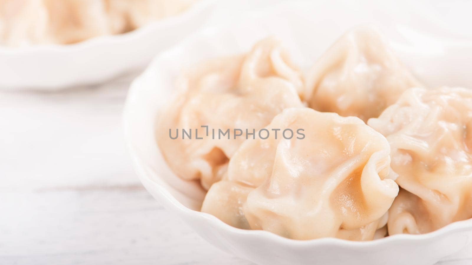 Fresh, delicious boiled pork, shrimp gyoza dumplings on white background with soy sauce and chopsticks, close up, lifestyle. Homemade design concept.