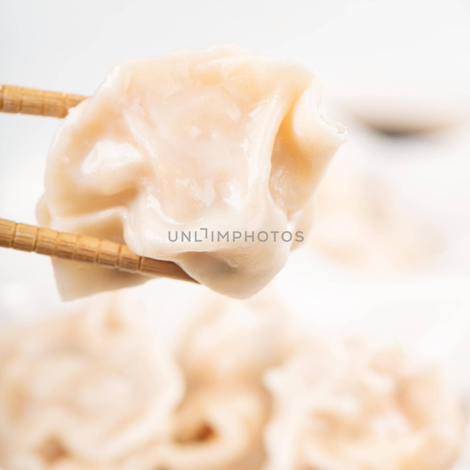Fresh, delicious boiled pork, shrimp gyoza dumplings on white background with soy sauce and chopsticks, close up, lifestyle. Homemade design concept.