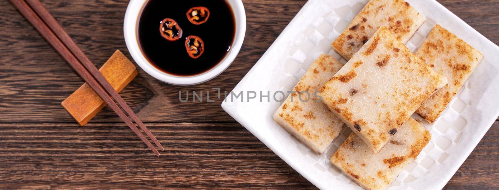 Delicious turnip cake, Chinese traditional radish cake in restaurant with soy sauce for new year's dishes, close up, copy space, top view, flat lay.