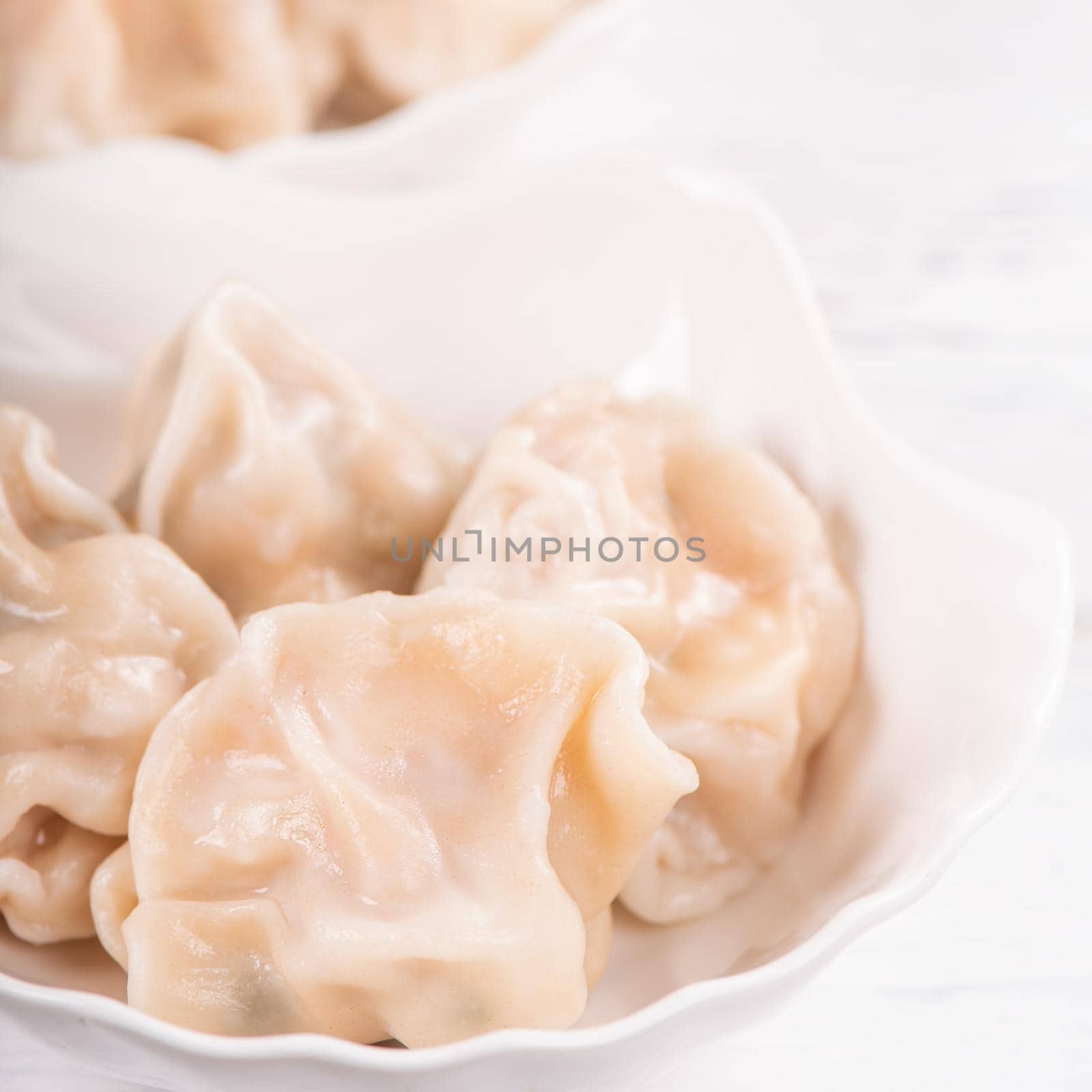 Fresh, delicious boiled pork, shrimp gyoza dumplings on white background with soy sauce and chopsticks, close up, lifestyle. Homemade design concept. by ROMIXIMAGE