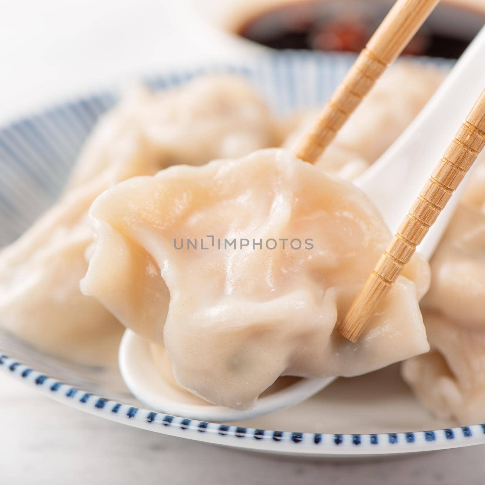 Fresh, delicious boiled pork, shrimp gyoza dumplings on white background with soy sauce and chopsticks, close up, lifestyle. Homemade design concept.