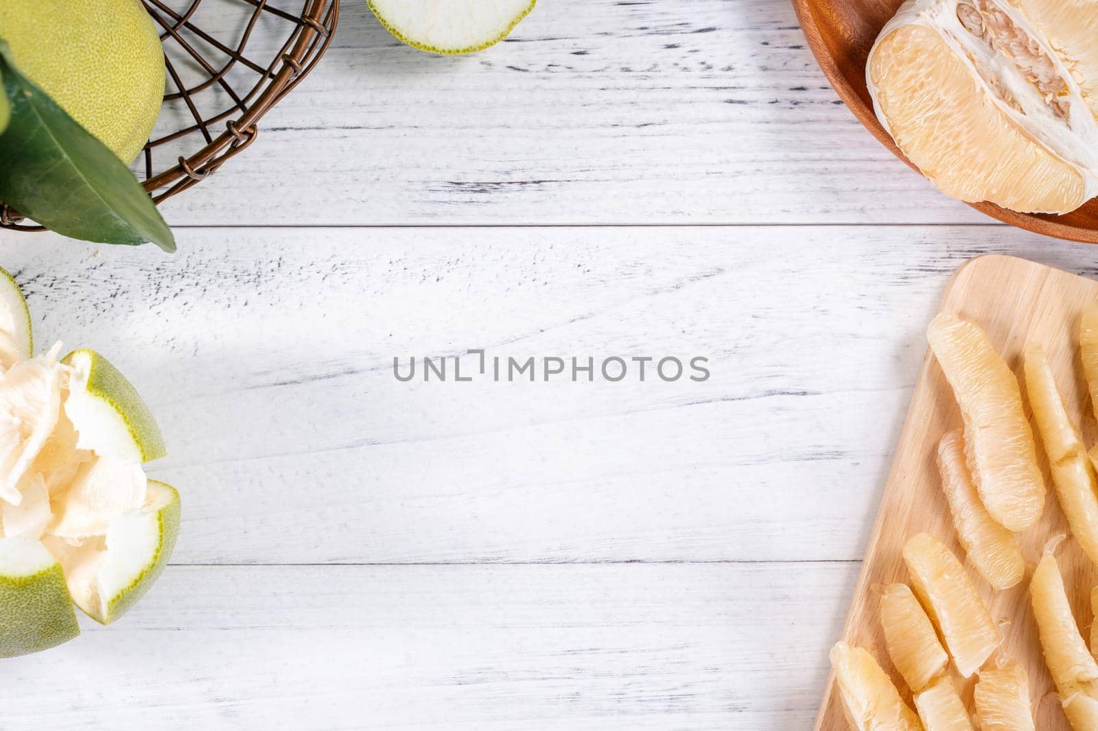 Fresh peeled pomelo, pummelo, grapefruit, shaddock on bright wooden background. Autumn seasonal fruit, top view, flat lay, tabletop shot.