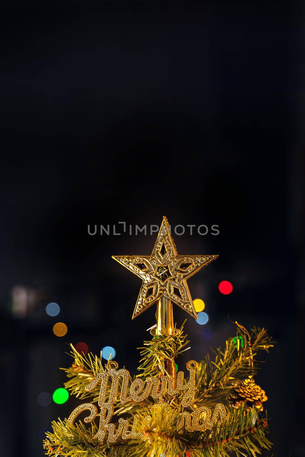 Beautiful Christmas decor concept, bauble hanging on the Christmas tree with sparkling light spot, blurry dark black background, macro detail, close up.