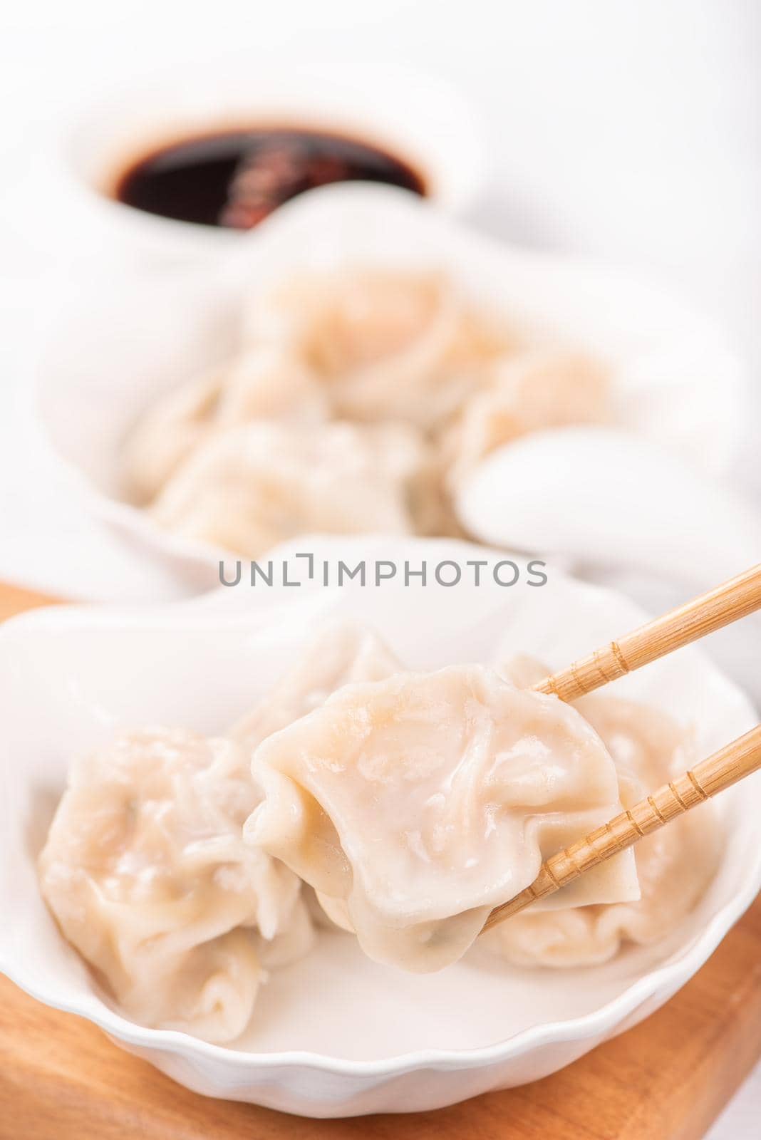 Fresh, delicious boiled pork, shrimp gyoza dumplings on white background with soy sauce and chopsticks, close up, lifestyle. Homemade design concept.