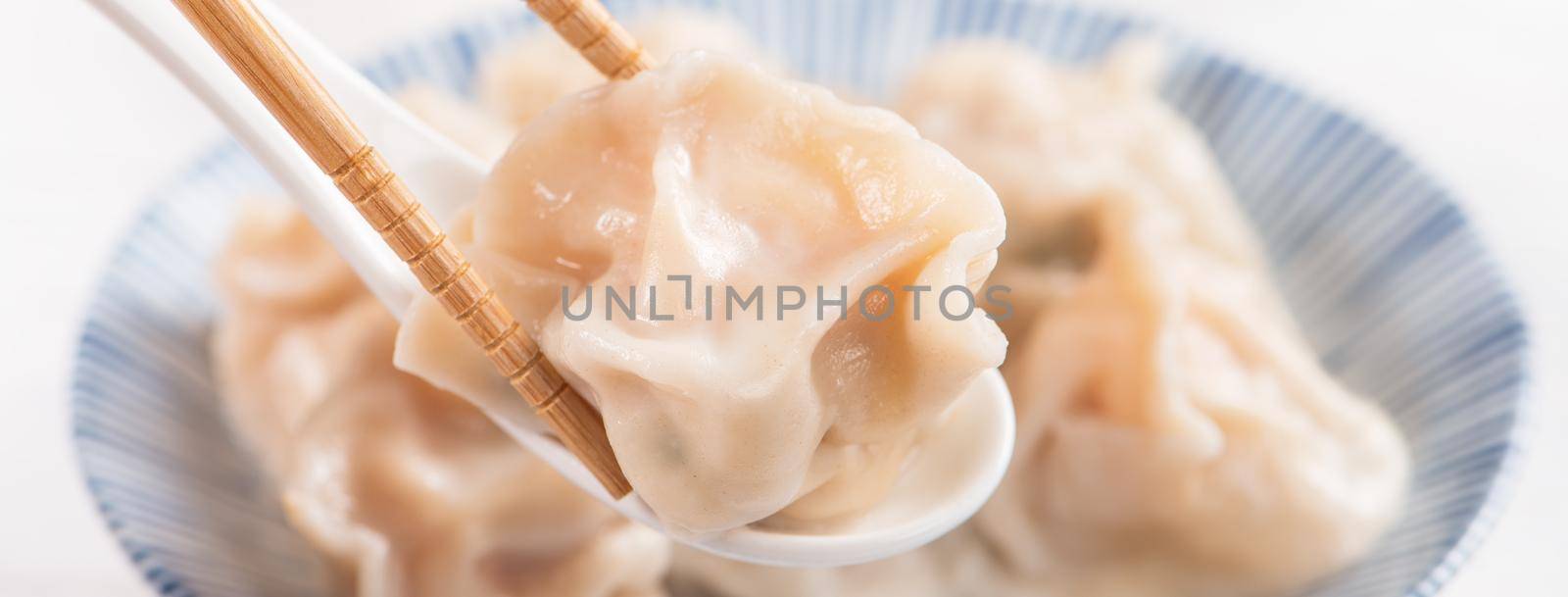 Fresh, delicious boiled pork, shrimp gyoza dumplings on white background with soy sauce and chopsticks, close up, lifestyle. Homemade design concept.