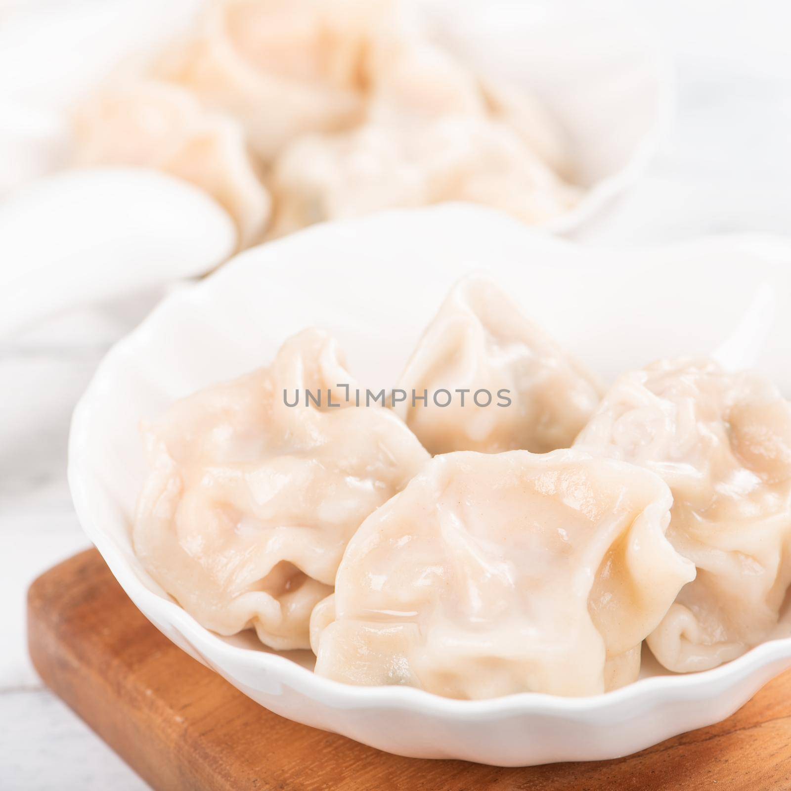 Fresh, delicious boiled pork gyoza dumplings, jiaozi on white background with soy sauce and chopsticks, close up, lifestyle. Homemade design concept. by ROMIXIMAGE