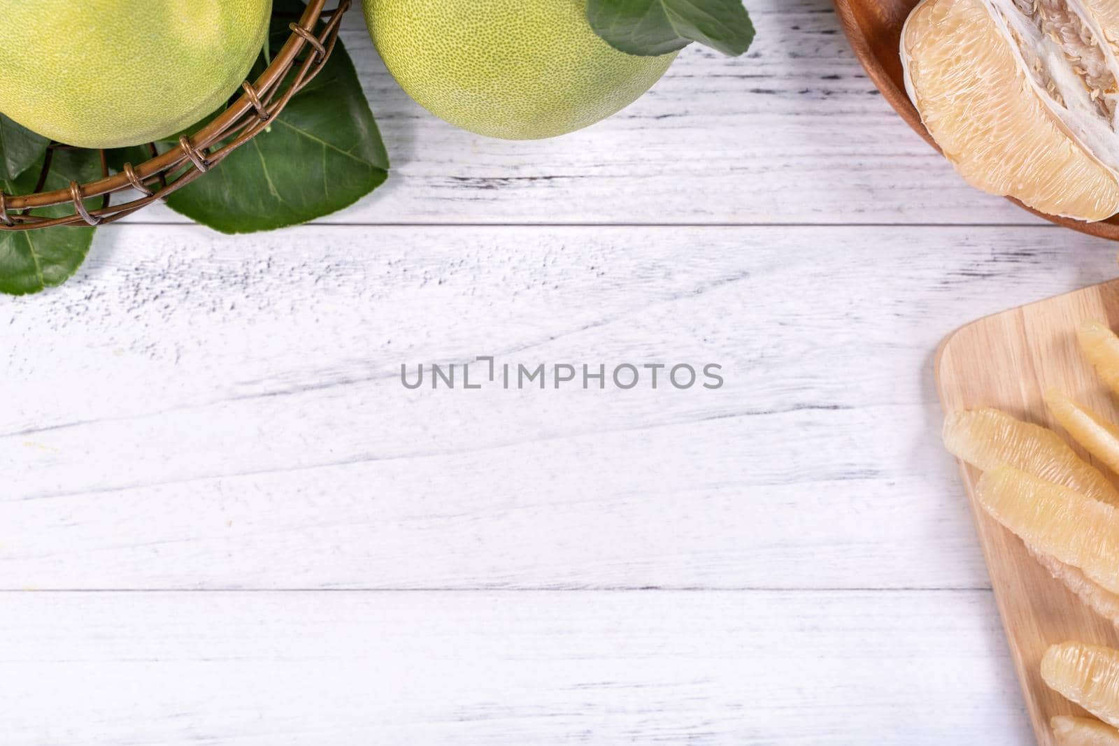 Fresh peeled pomelo, pummelo, grapefruit, shaddock on bright wooden background. Autumn seasonal fruit, top view, flat lay, tabletop shot.