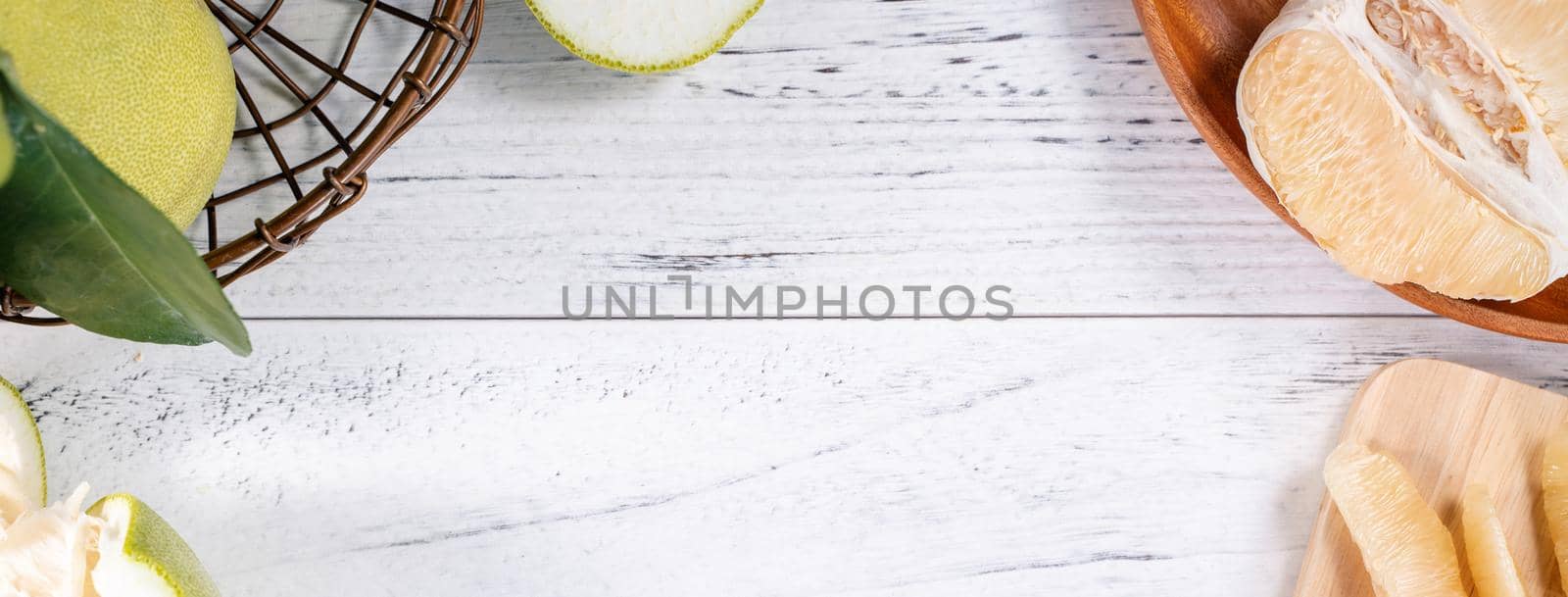 Fresh peeled pomelo, pummelo, grapefruit, shaddock on bright wooden background. Autumn seasonal fruit, top view, flat lay, tabletop shot. by ROMIXIMAGE