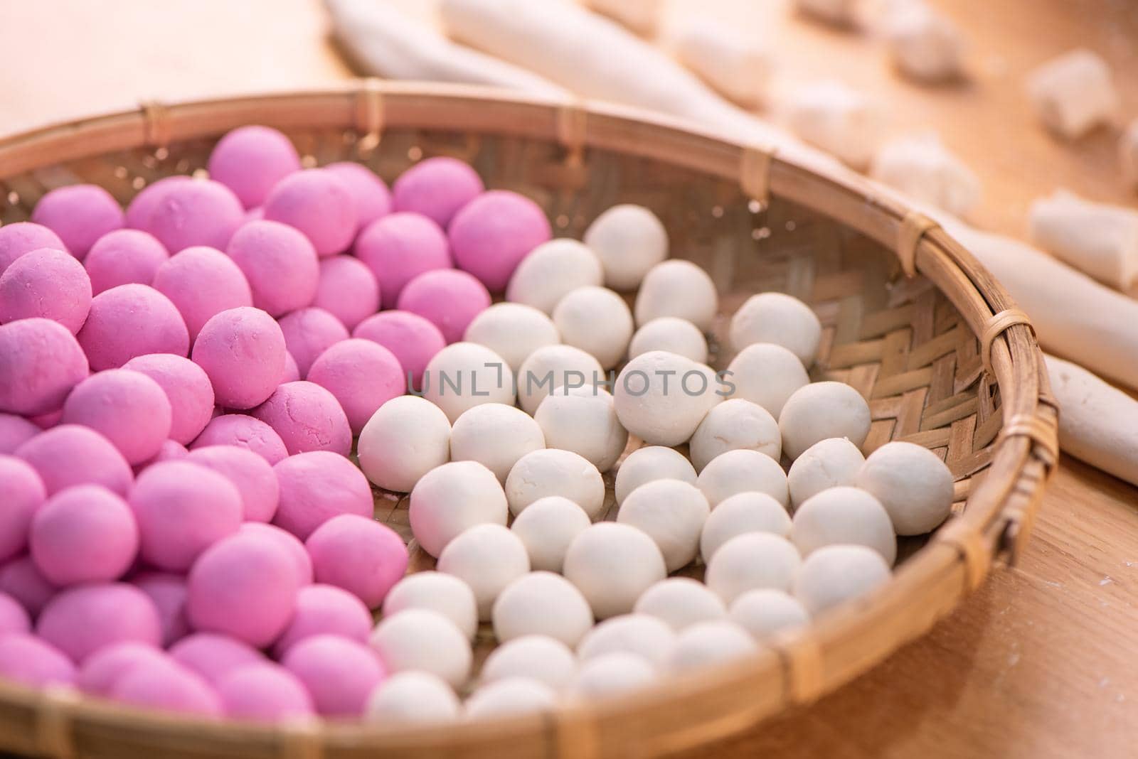 An Asia woman is making Tang yuan, yuan xiao, Chinese traditional food rice dumplings in red and white for lunar new year, winter festival, close up.