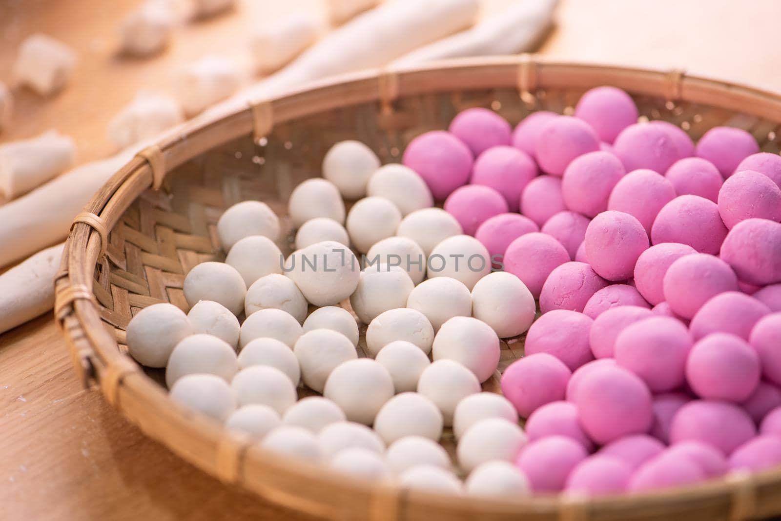 An Asia woman is making Tang yuan, yuan xiao, Chinese traditional food rice dumplings in red and white for lunar new year, winter festival, close up.