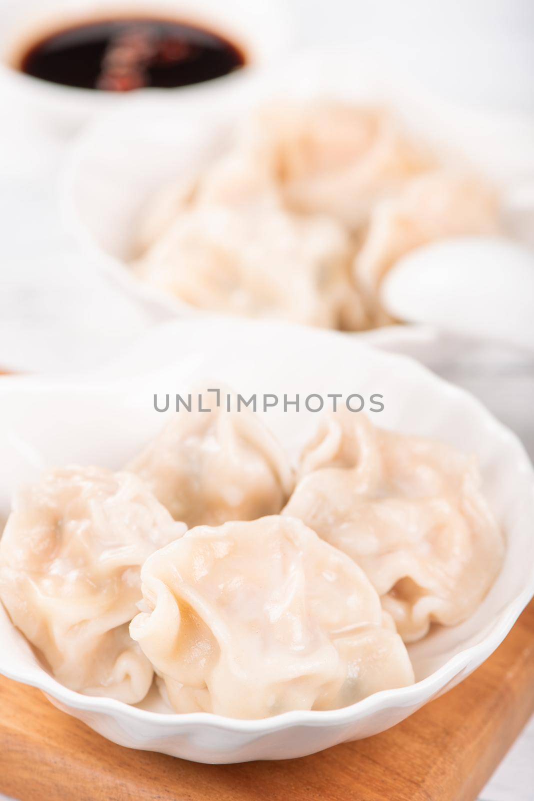 Fresh, delicious boiled pork gyoza dumplings, jiaozi on white background with soy sauce and chopsticks, close up, lifestyle. Homemade design concept.