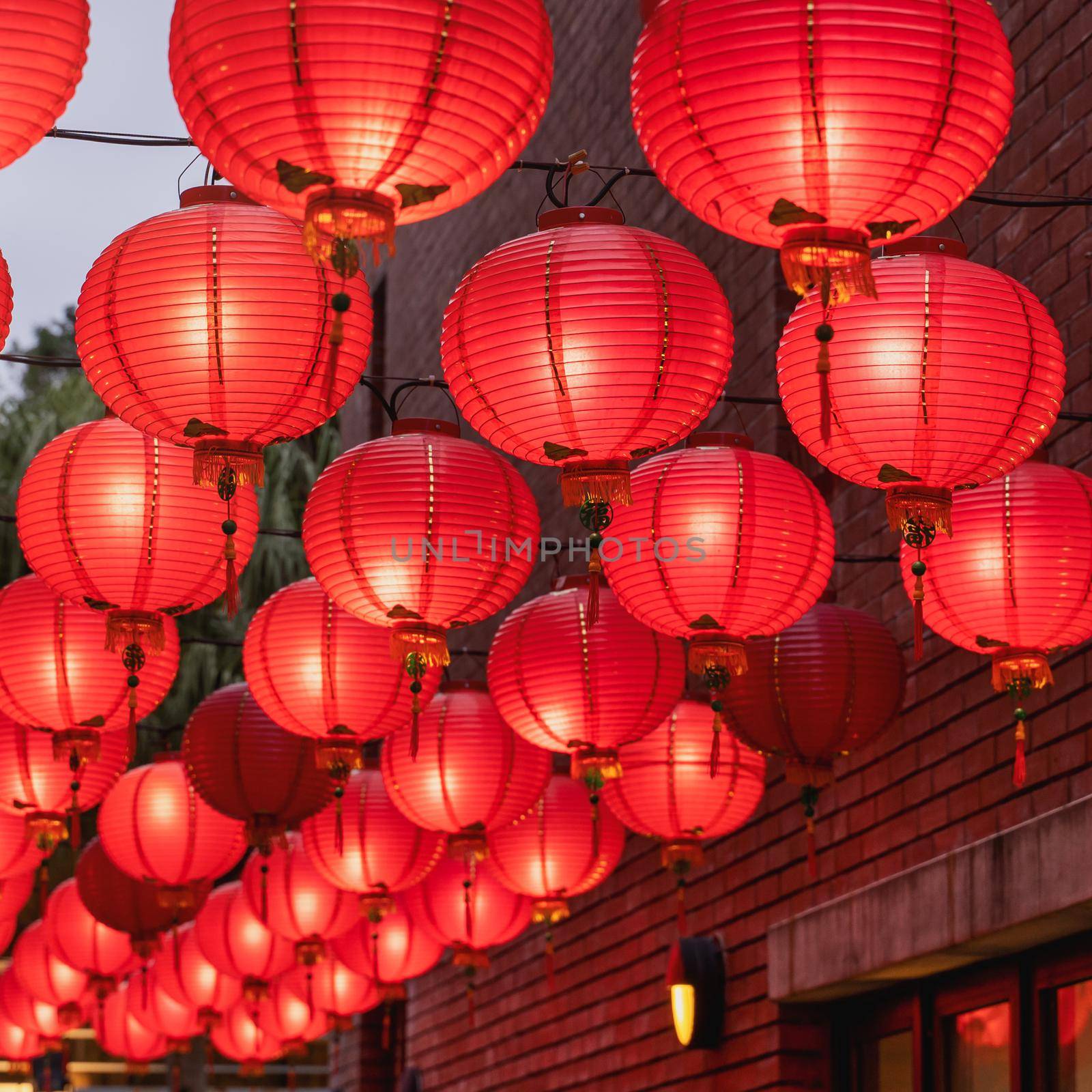 Beautiful round red lantern hanging on old traditional street, concept of Chinese lunar new year festival, close up. The undering word means blessing.