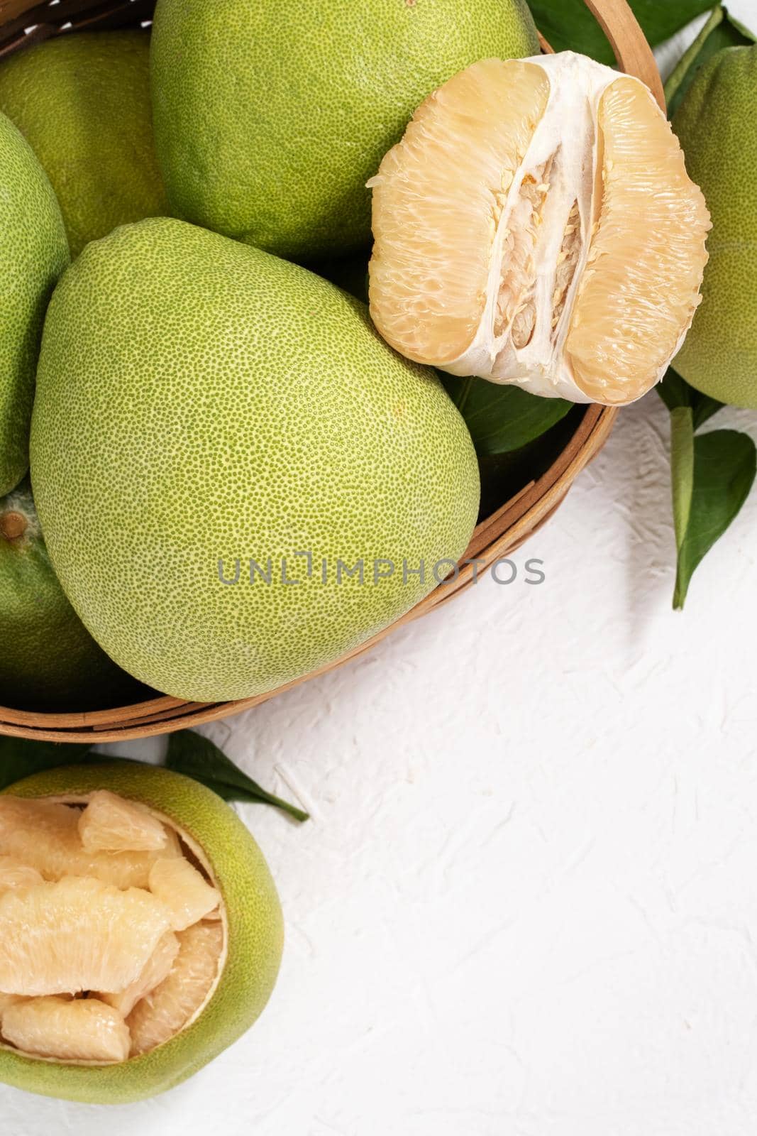 Fresh peeled pomelo, pummelo, grapefruit, shaddock on bright wooden background. Autumn seasonal fruit, top view, flat lay, tabletop shot. by ROMIXIMAGE