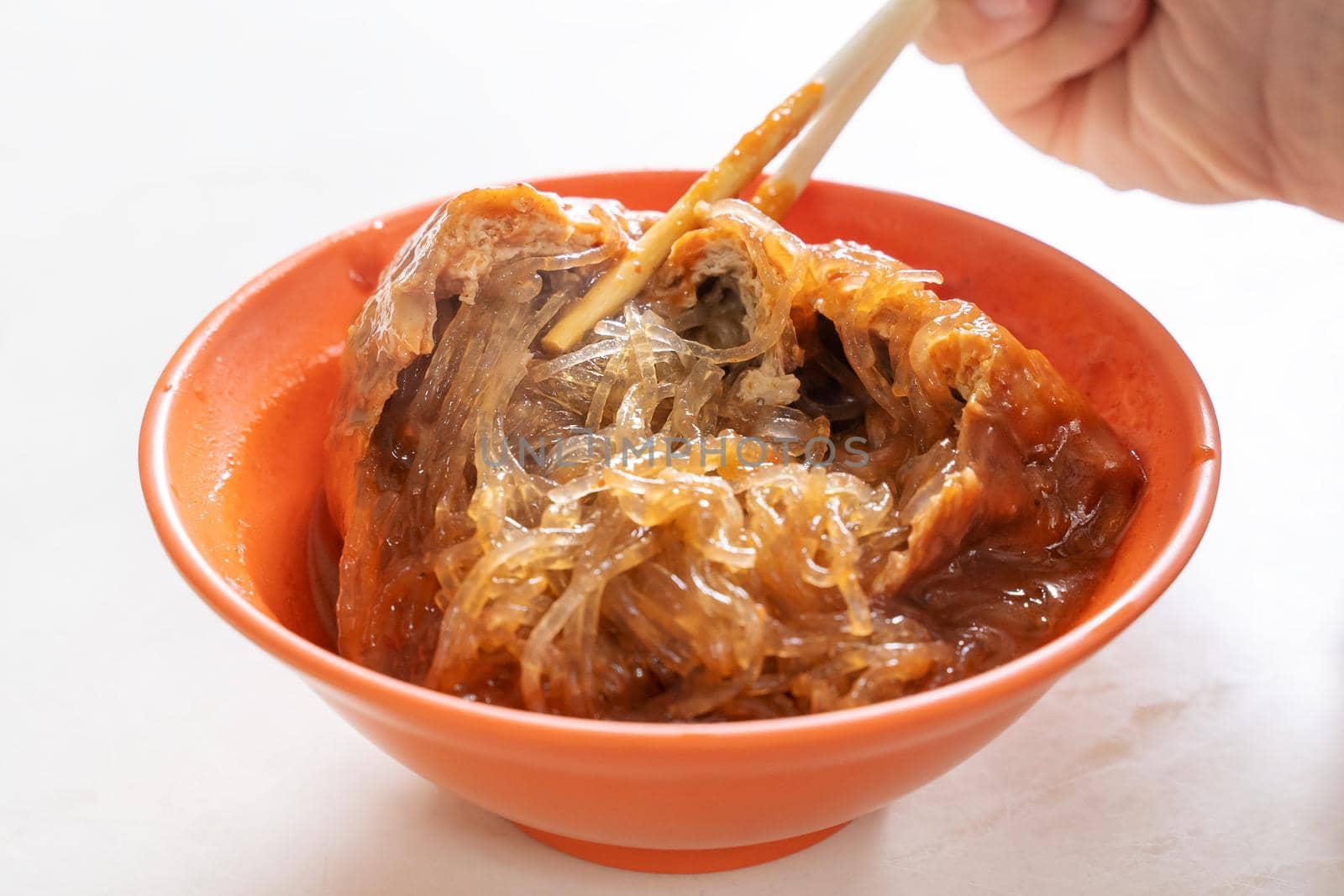 Tamsui agei (age, aburaage), delicious famous street food in Taipei, Taiwan, stuffed with mung bean noodles and chili sauce topping, lifestyle, close up.
