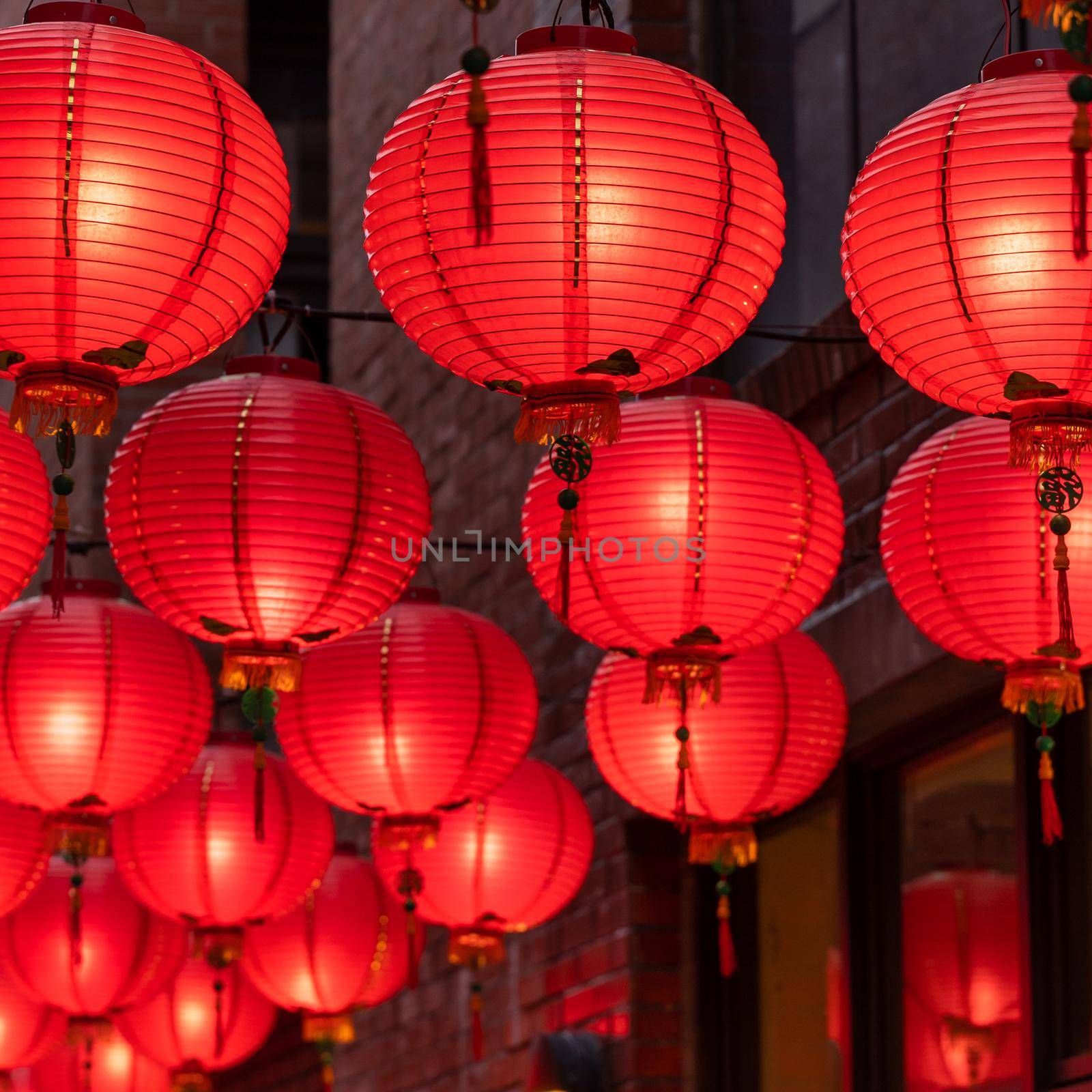 Beautiful round red lantern hanging on old traditional street, concept of Chinese lunar new year festival, close up. The undering word means blessing. by ROMIXIMAGE