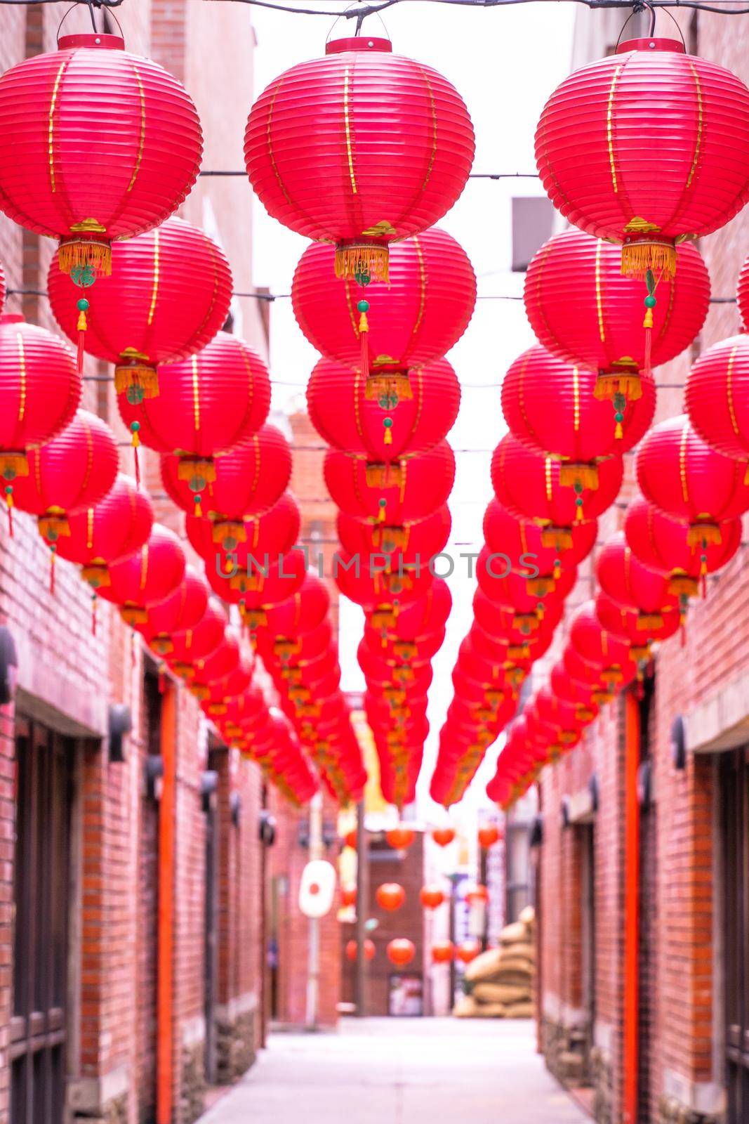 Beautiful round red lantern hanging on old traditional street, concept of Chinese lunar new year festival, close up. The undering word means blessing. by ROMIXIMAGE