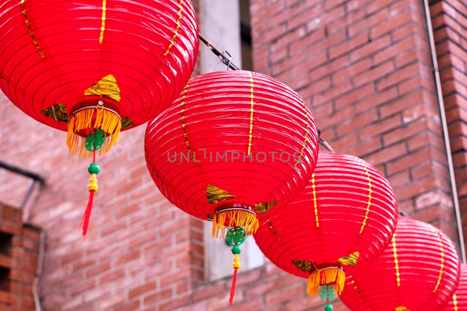 Beautiful round red lantern hanging on old traditional street, concept of Chinese lunar new year festival, close up. The undering word means blessing.