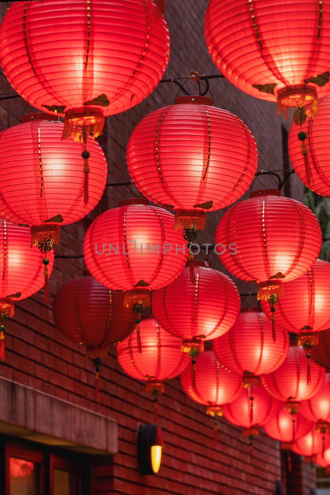 Beautiful round red lantern hanging on old traditional street, concept of Chinese lunar new year festival, close up. The undering word means blessing. by ROMIXIMAGE