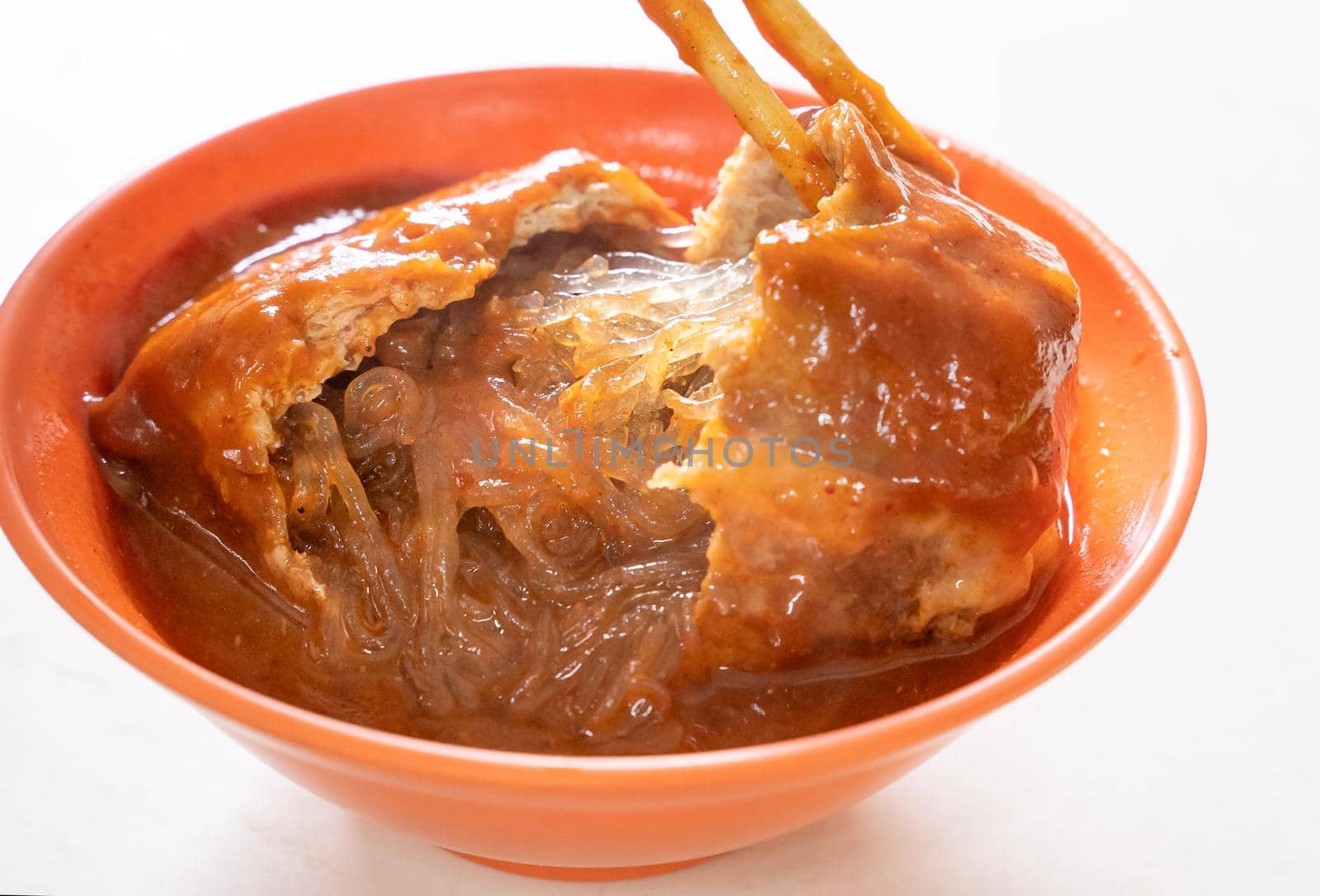 Tamsui agei (age, aburaage), delicious famous street food in Taipei, Taiwan, stuffed with mung bean noodles and chili sauce topping, lifestyle, close up.