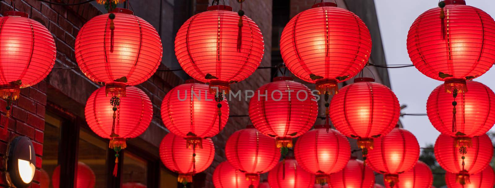 Beautiful round red lantern hanging on old traditional street, concept of Chinese lunar new year festival, close up. The undering word means blessing.