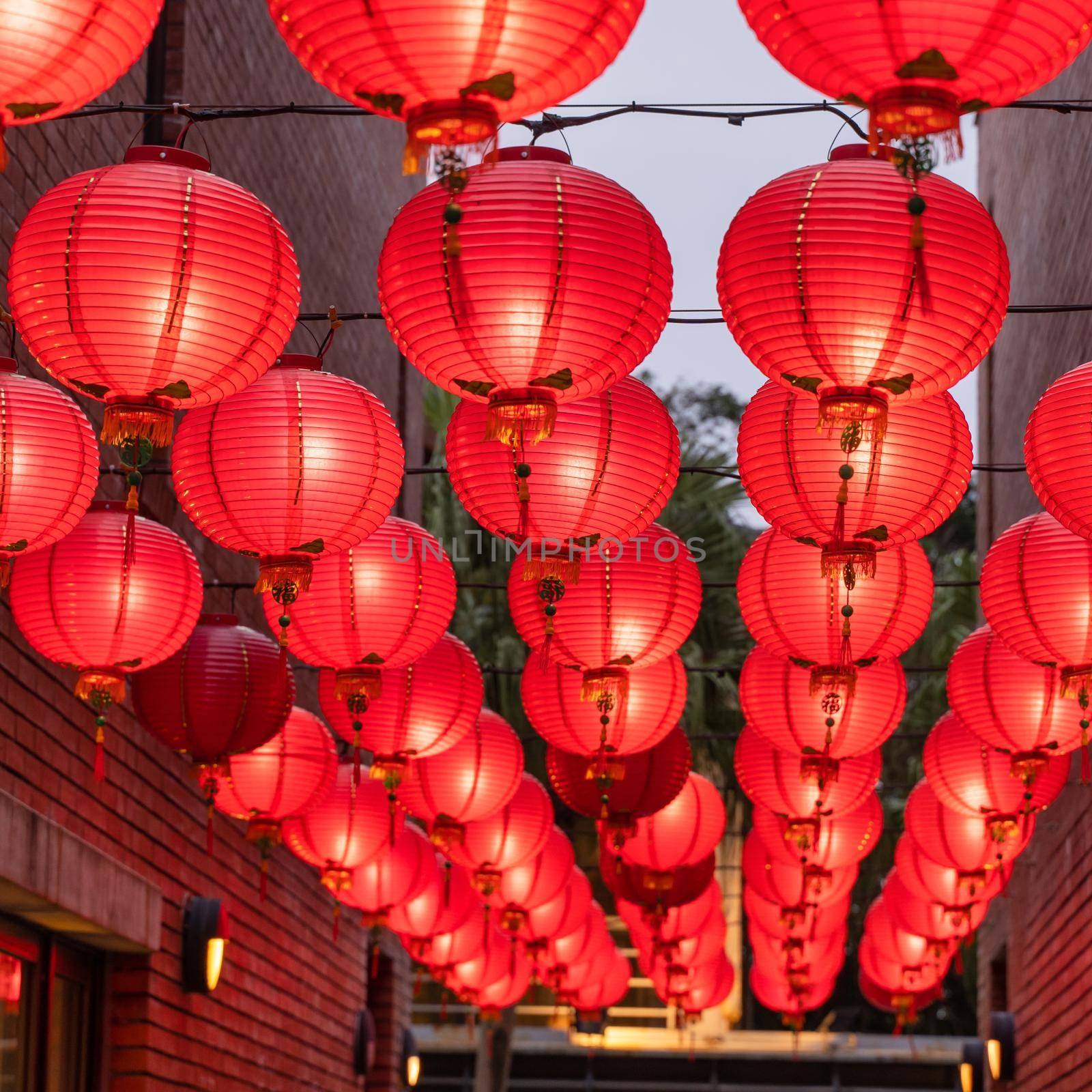 Beautiful round red lantern hanging on old traditional street, concept of Chinese lunar new year festival, close up. The undering word means blessing. by ROMIXIMAGE