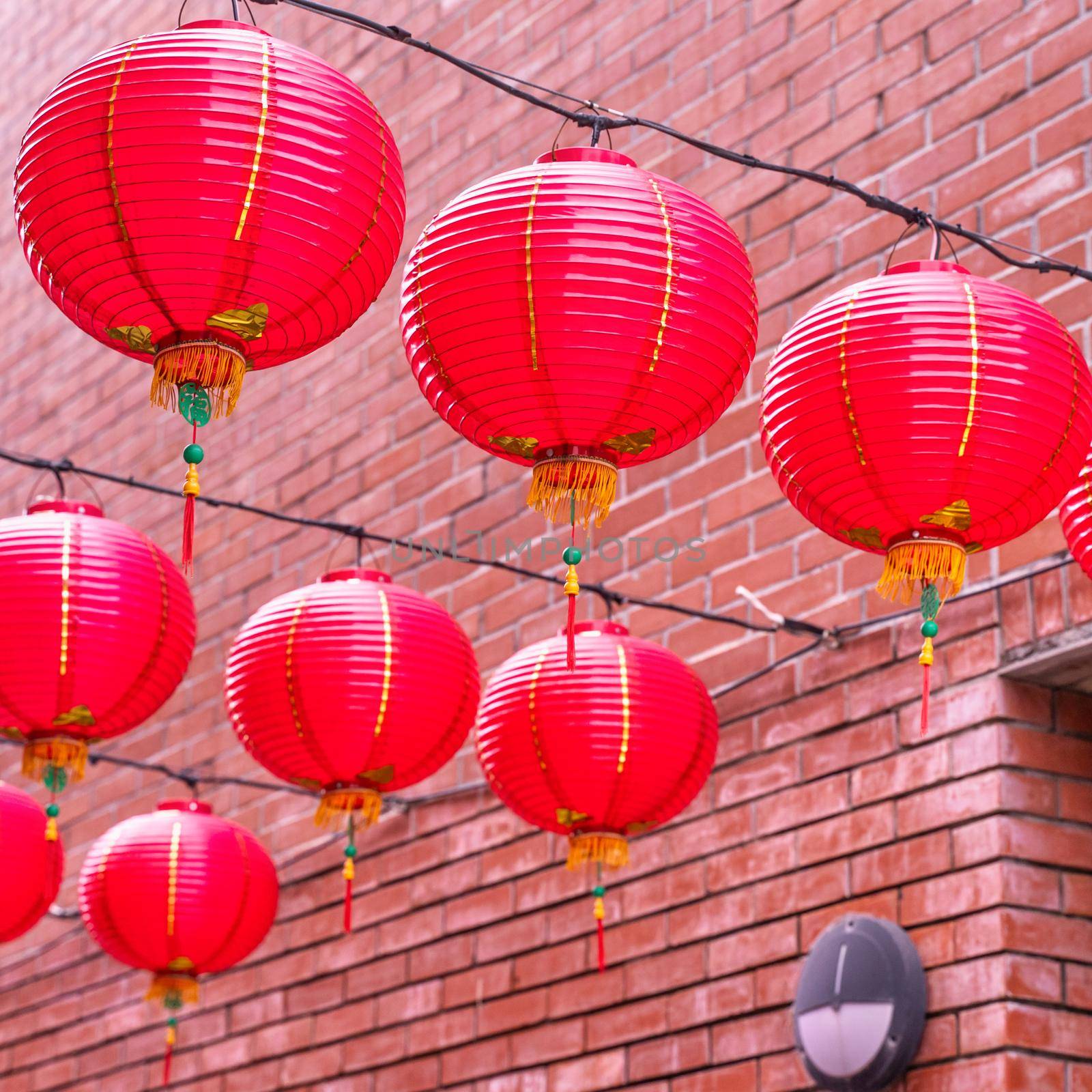 Beautiful round red lantern hanging on old traditional street, concept of Chinese lunar new year festival, close up. The undering word means blessing.