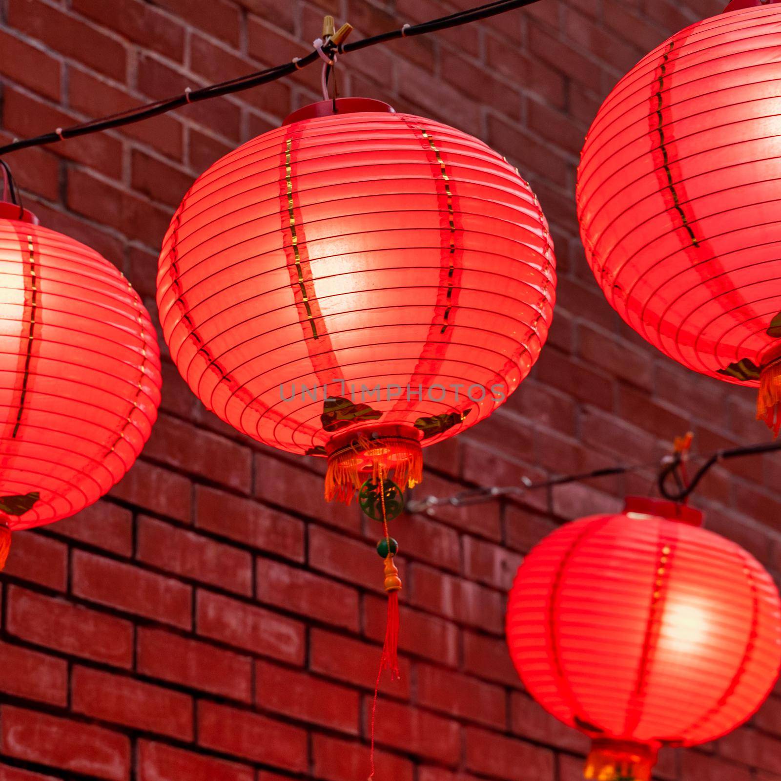 Beautiful round red lantern hanging on old traditional street, concept of Chinese lunar new year festival, close up. The undering word means blessing.