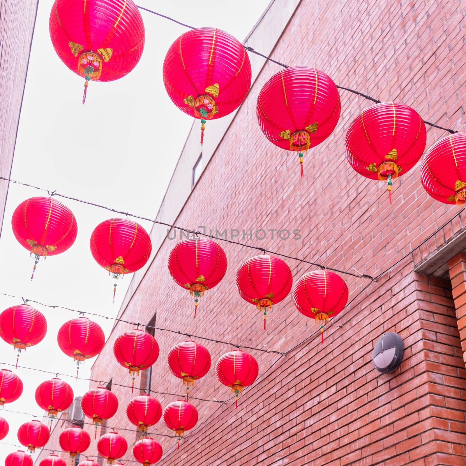 Beautiful round red lantern hanging on old traditional street, concept of Chinese lunar new year festival, close up. The undering word means blessing.