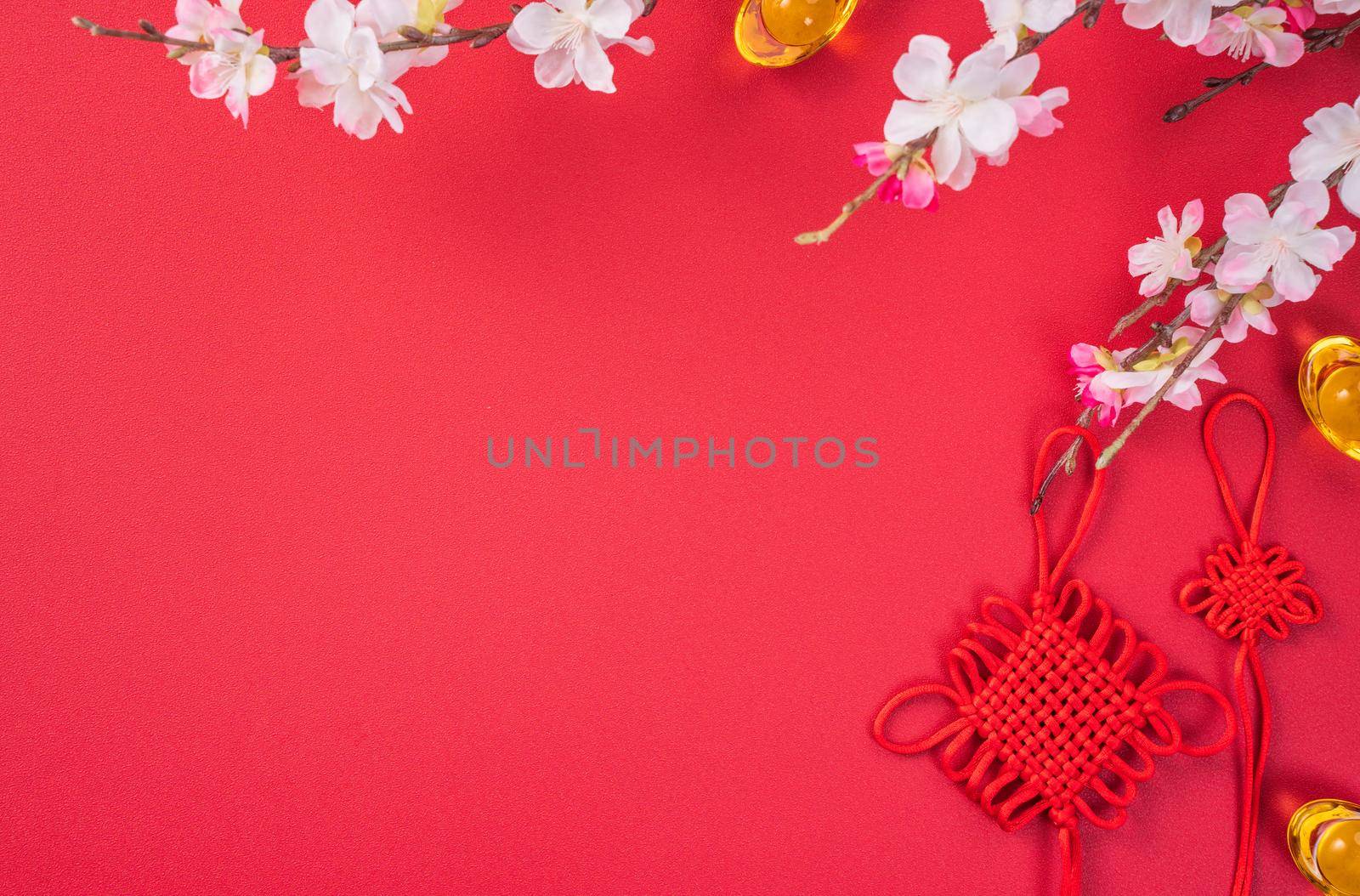 Design concept of Chinese lunar new year - Beautiful Chinese knot with plum blossom isolated on red background, flat lay, top view, overhead layout.
