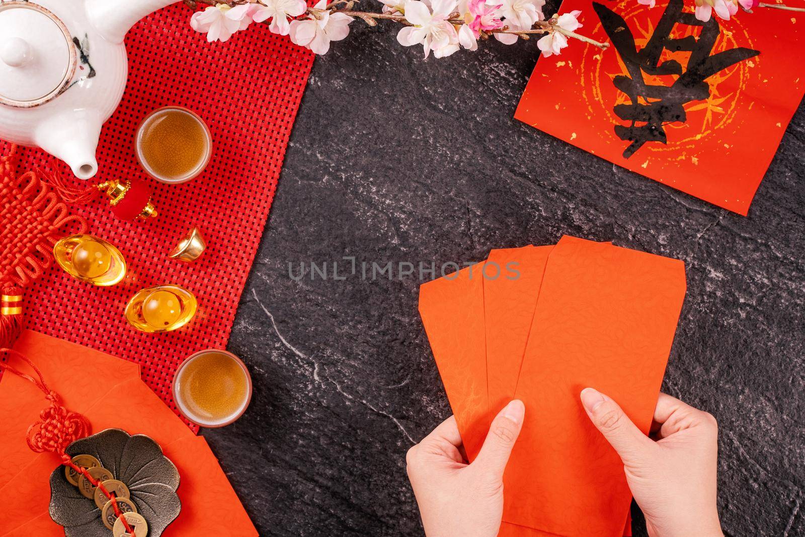 Design concept of Chinese lunar January new year - Woman holding, giving red envelopes (ang pow, hong bao) for lucky money, top view, flat lay, overhead above. The word 'chun' means coming spring.