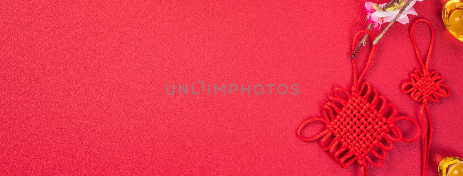 Design concept of Chinese lunar new year - Beautiful Chinese knot with plum blossom isolated on red background, flat lay, top view, overhead layout. by ROMIXIMAGE