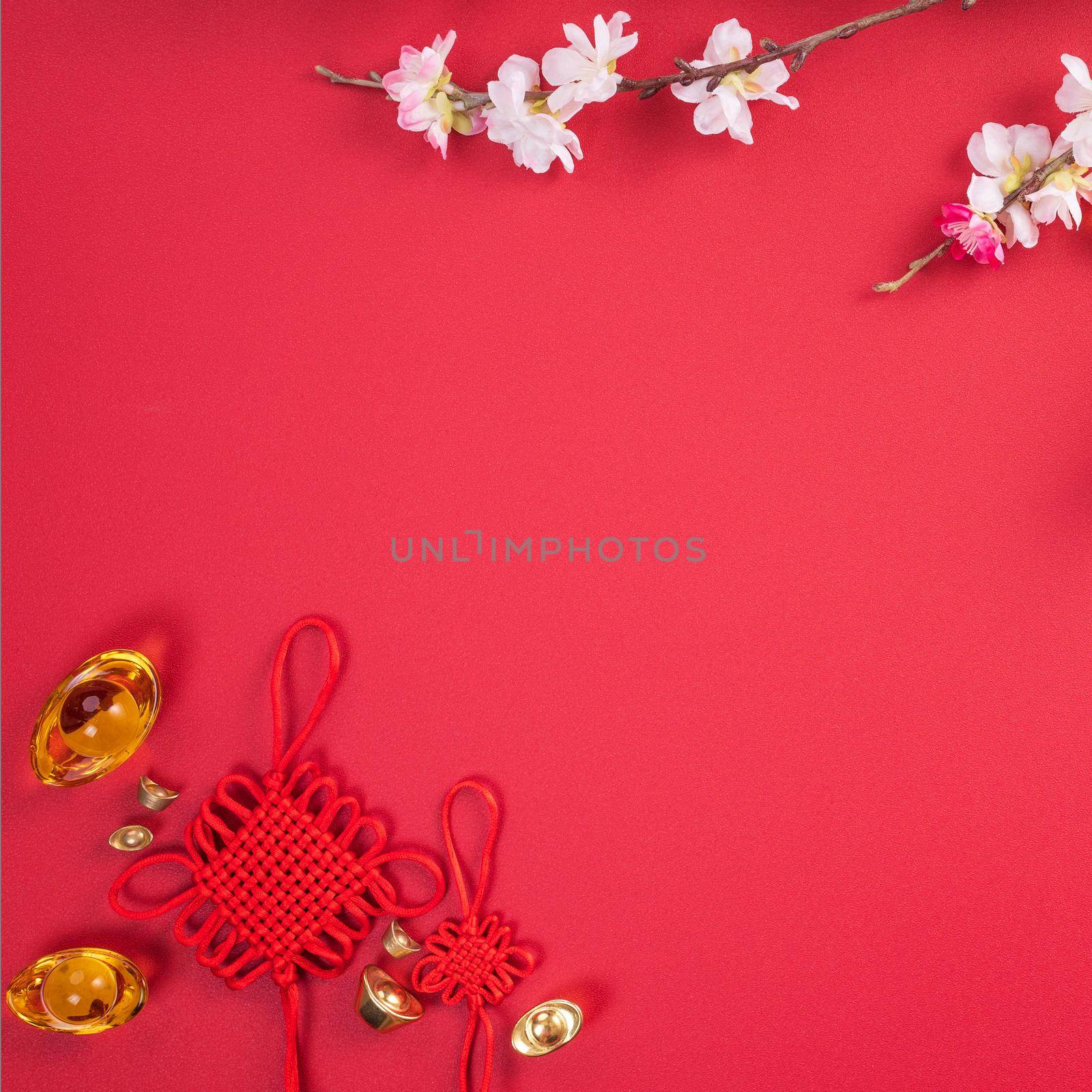 Design concept of Chinese lunar new year - Beautiful Chinese knot with plum blossom isolated on red background, flat lay, top view, overhead layout. by ROMIXIMAGE