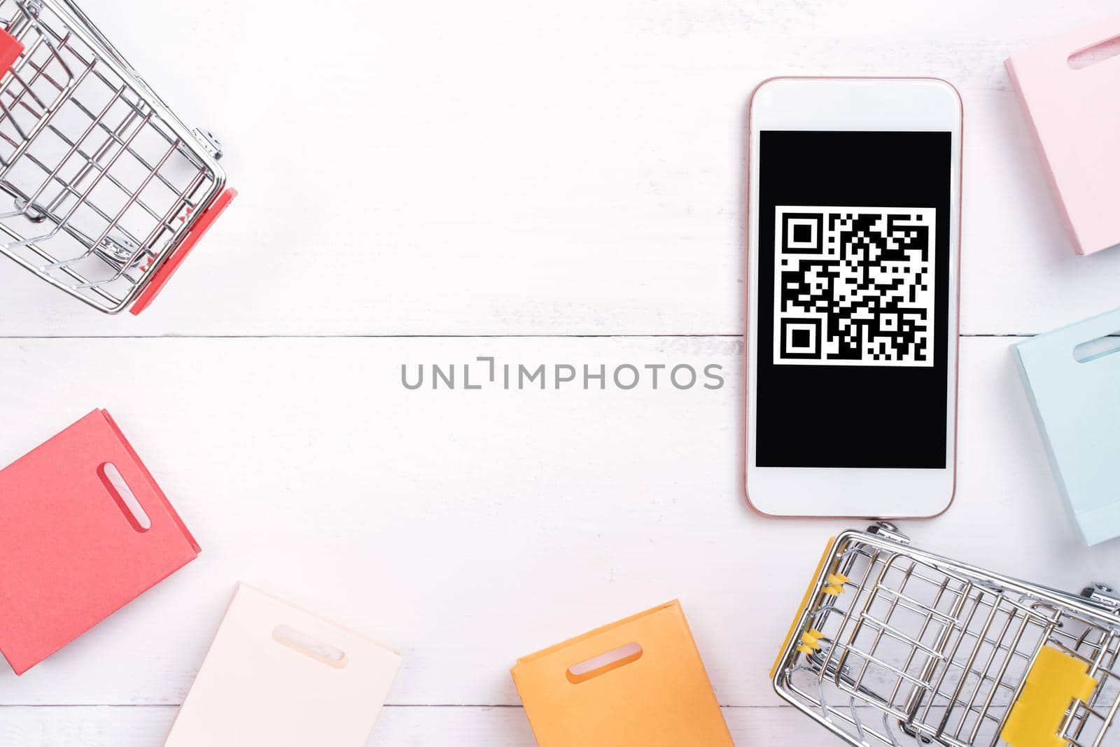 Abstract online shopping, mobile payment with QR code design concept element, colorful cart, paper bag on wooden table background, top view, flat lay