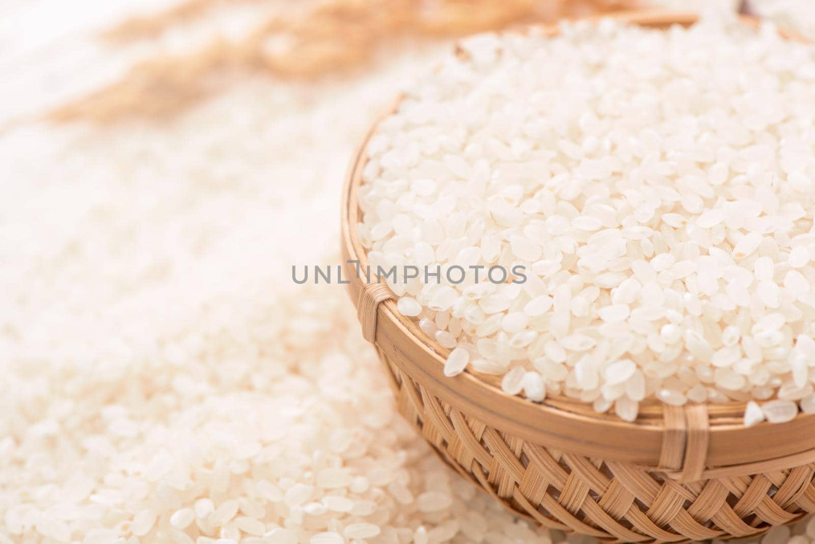 Raw white polished milled edible rice crop on white background in brown bowl, organic agriculture design concept. Staple food of Asia, close up.