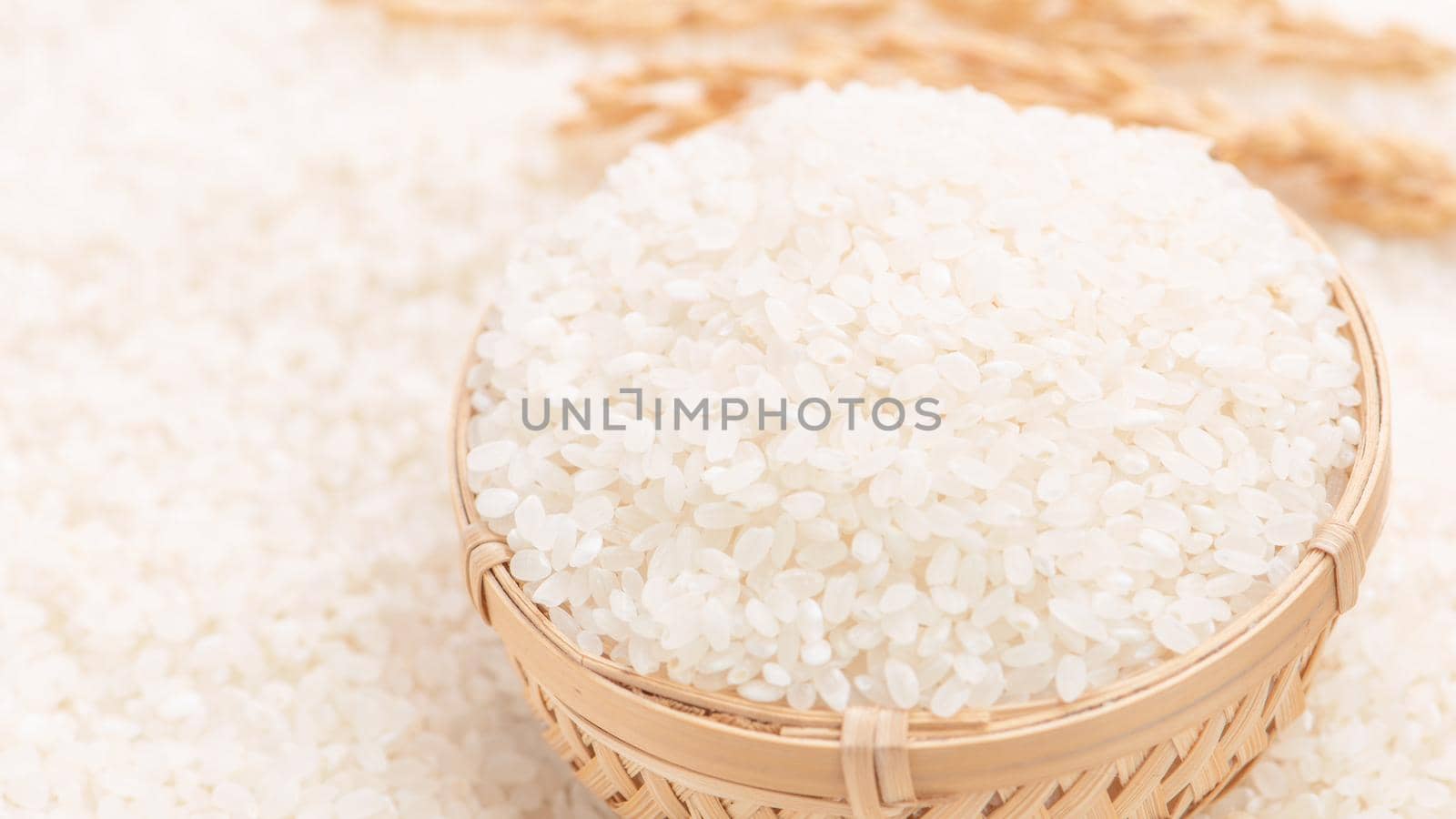 Raw white polished milled edible rice crop on white background in brown bowl, organic agriculture design concept. Staple food of Asia, close up.