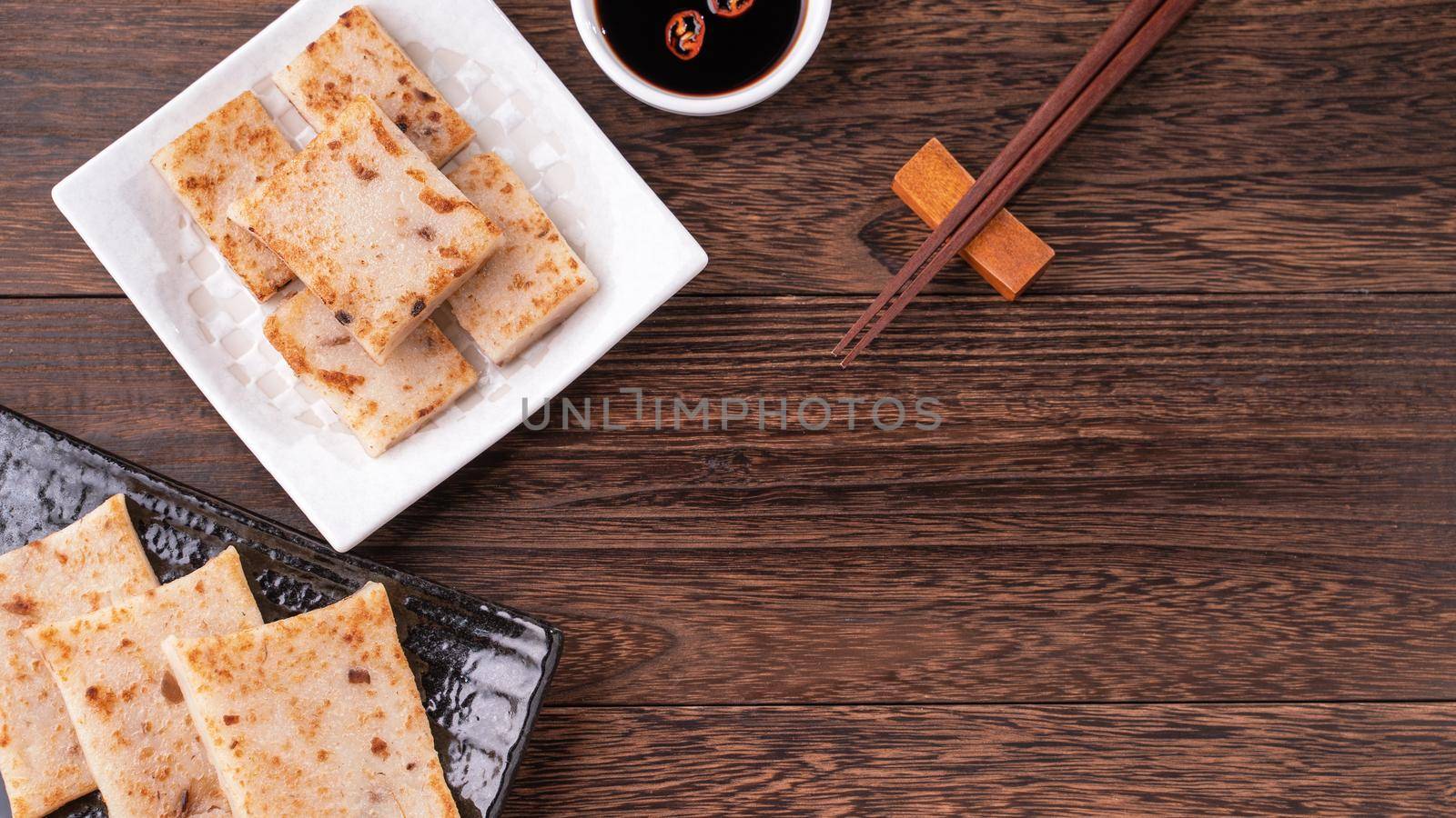Delicious turnip cake, Chinese traditional radish cake in restaurant with soy sauce for new year's dishes, close up, copy space, top view, flat lay.