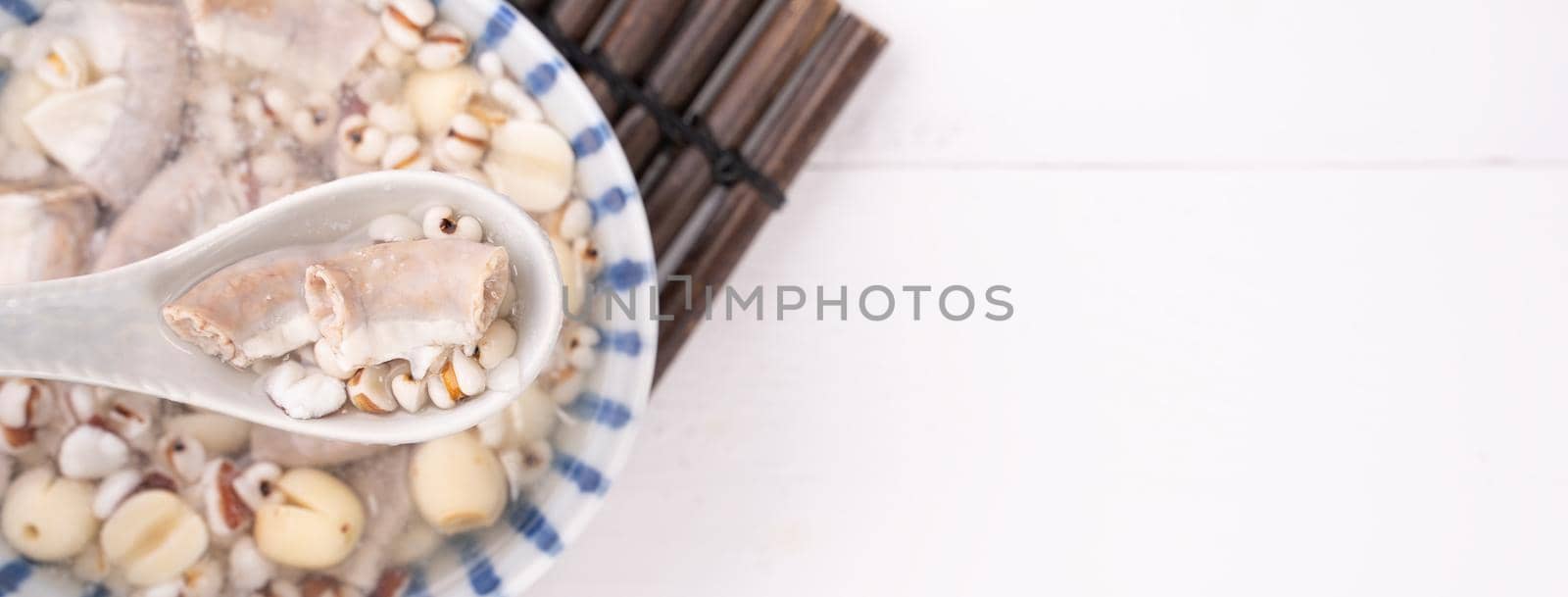 Tasty Four Tonics Herb Flavor Soup, Taiwanese traditional food with herbs, pork intestines on white wooden table, close up, flat lay, top view.