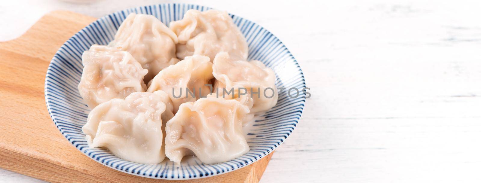 Fresh, delicious boiled pork, shrimp gyoza dumplings on white background with soy sauce and chopsticks, close up, lifestyle. Homemade design concept.