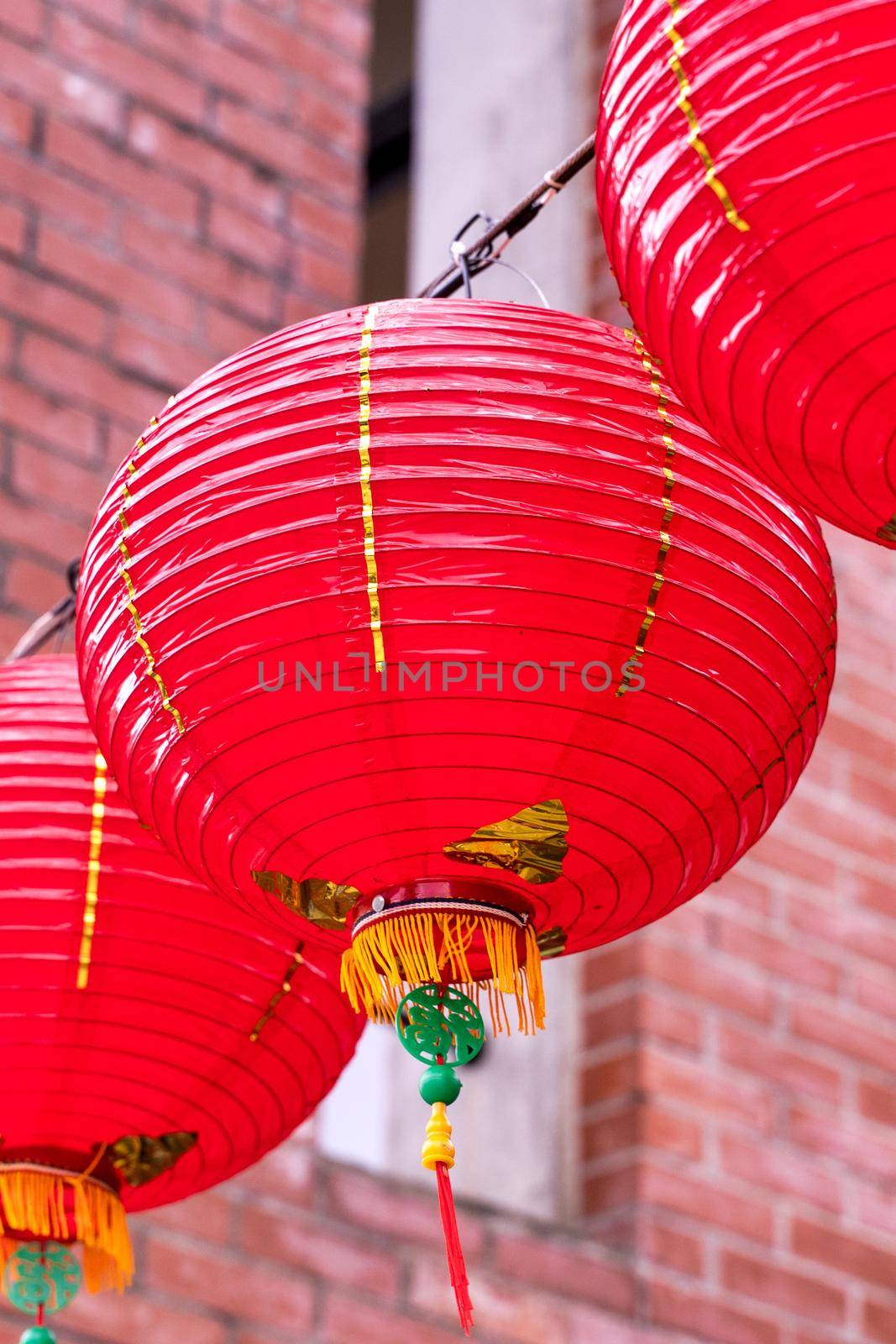 Beautiful round red lantern hanging on old traditional street, concept of Chinese lunar new year festival, close up. The undering word means blessing.