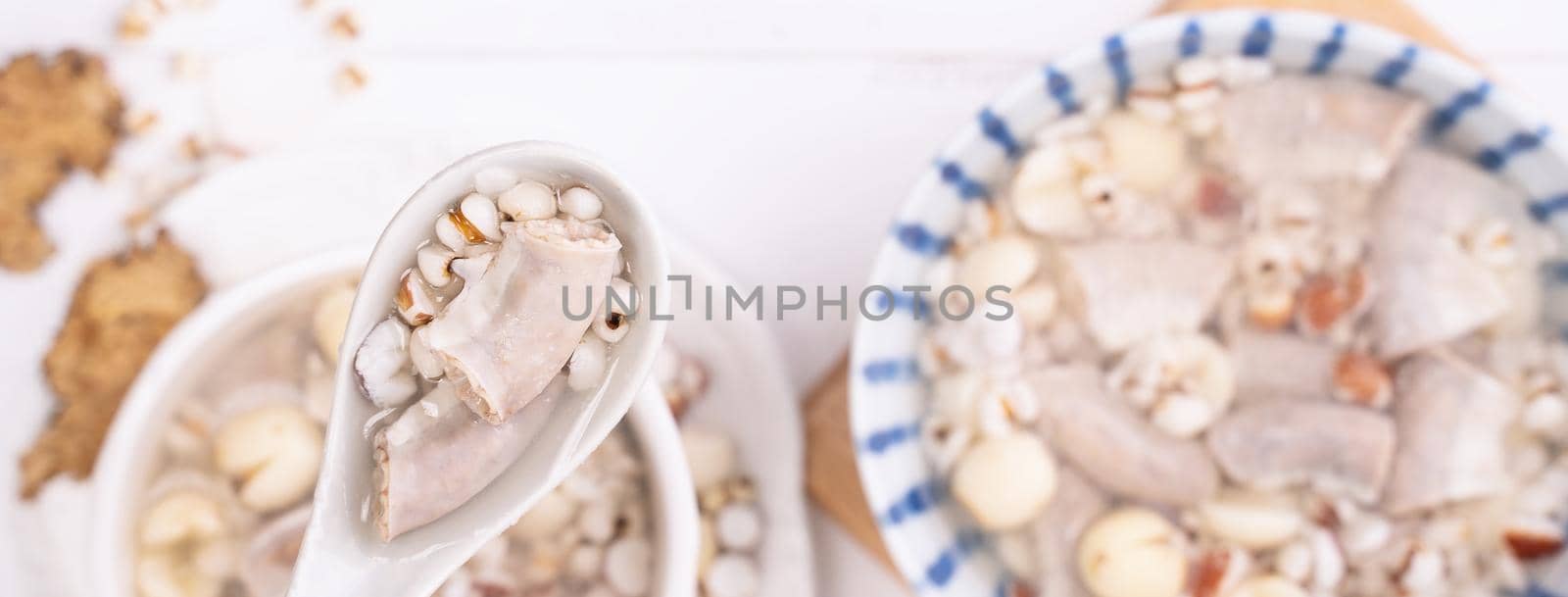 Tasty Four Tonics Herb Flavor Soup, Taiwanese traditional food with herbs, pork intestines on white wooden table, close up, flat lay, top view.