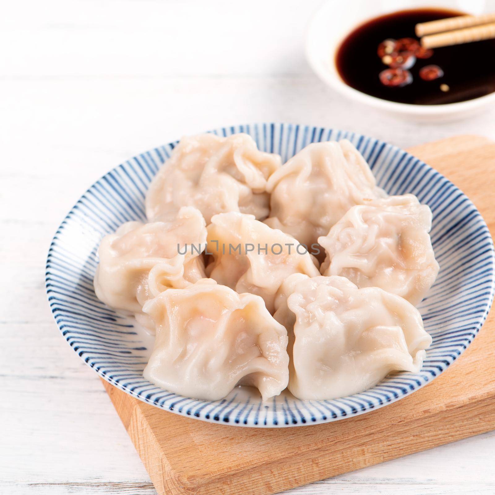 Fresh, delicious boiled pork gyoza dumplings, jiaozi on white background with soy sauce and chopsticks, close up, lifestyle. Homemade design concept.