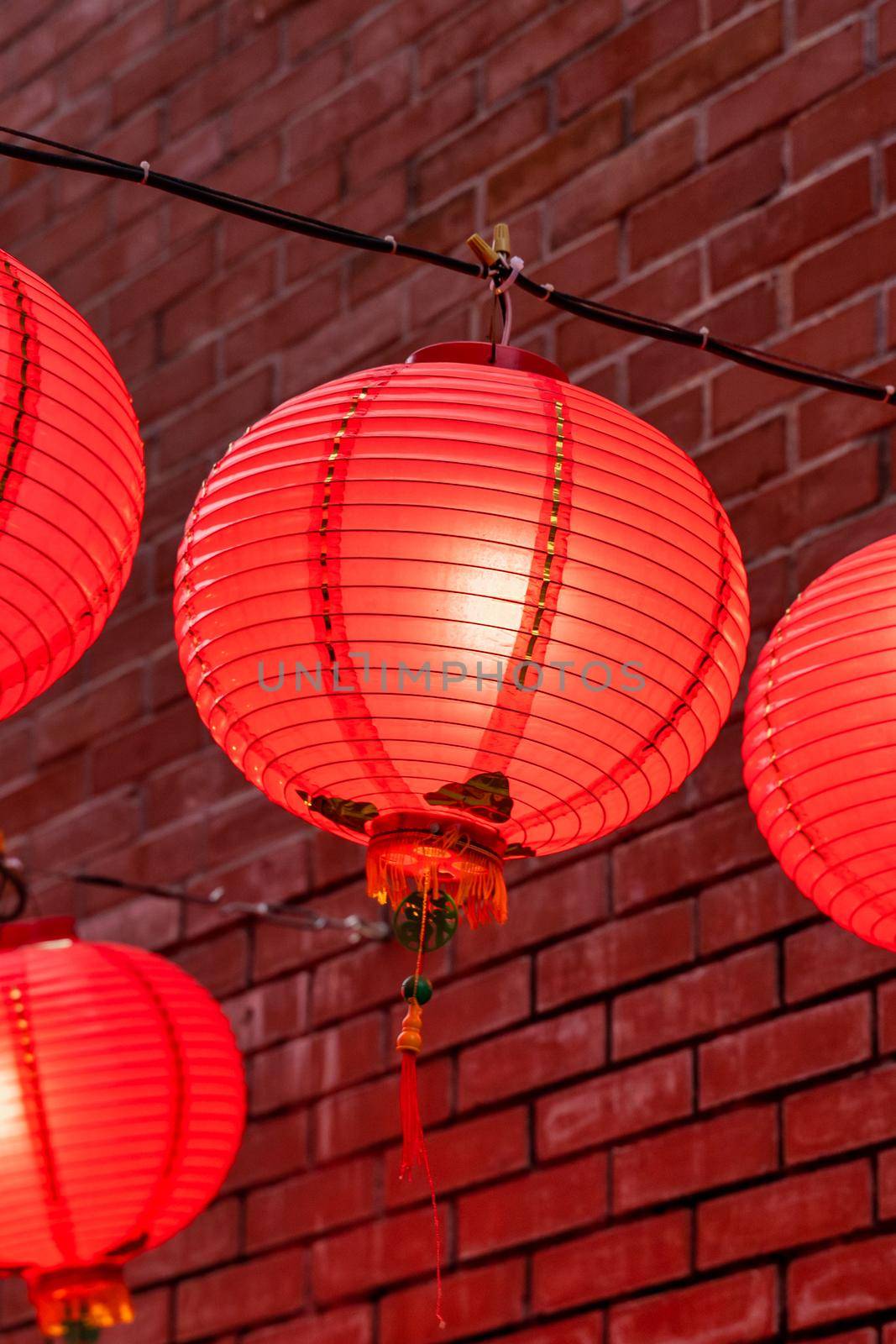 Beautiful round red lantern hanging on old traditional street, concept of Chinese lunar new year festival, close up. The undering word means blessing. by ROMIXIMAGE