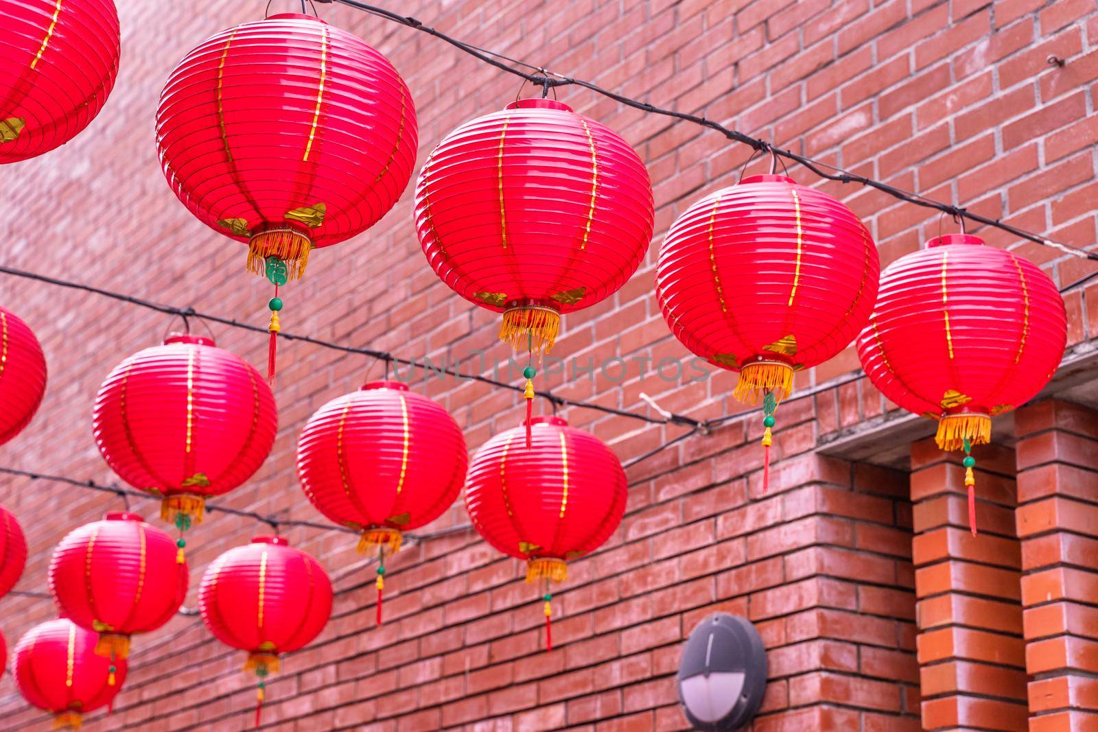 Beautiful round red lantern hanging on old traditional street, concept of Chinese lunar new year festival, close up. The undering word means blessing.