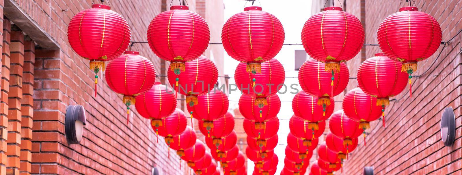 Beautiful round red lantern hanging on old traditional street, concept of Chinese lunar new year festival, close up. The undering word means blessing. by ROMIXIMAGE